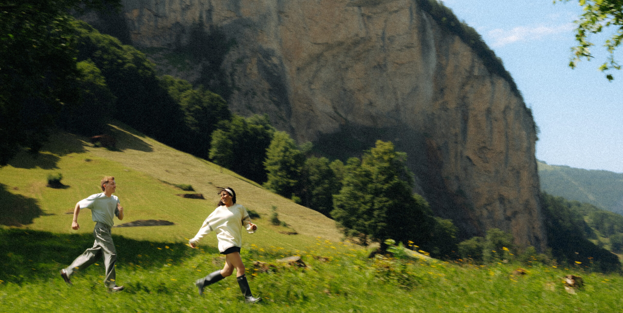 A cinematic photo of a couple running near the Swiss Alps.