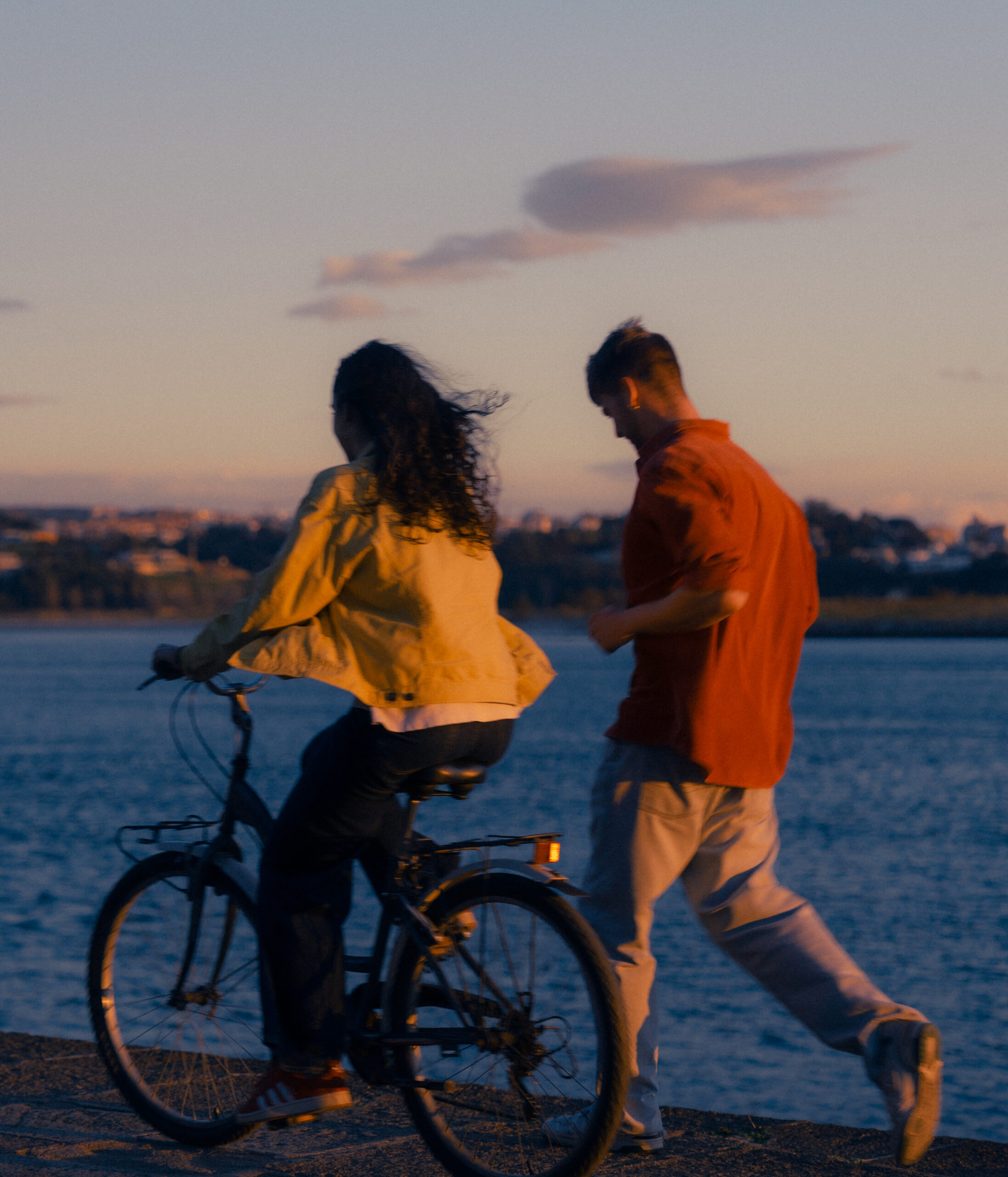 A cinematic photo of a couple with a bike in Porto.