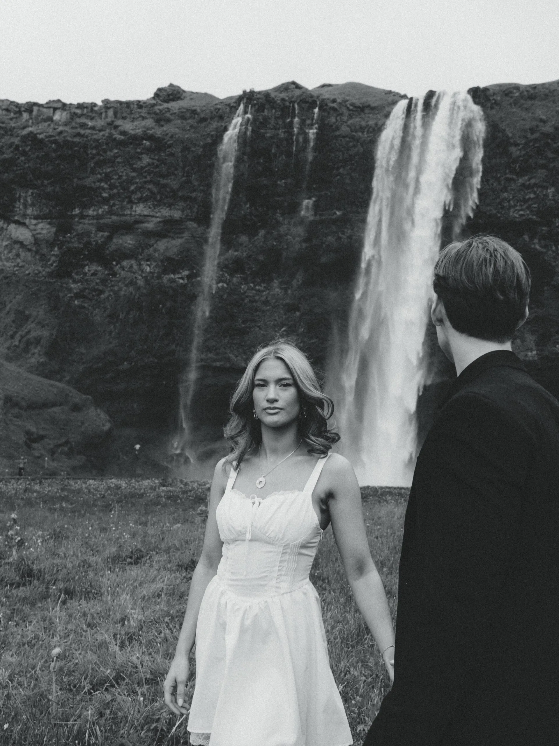 A cinematic portrait of a couple in front of a waterfall during their elopement in Iceland.