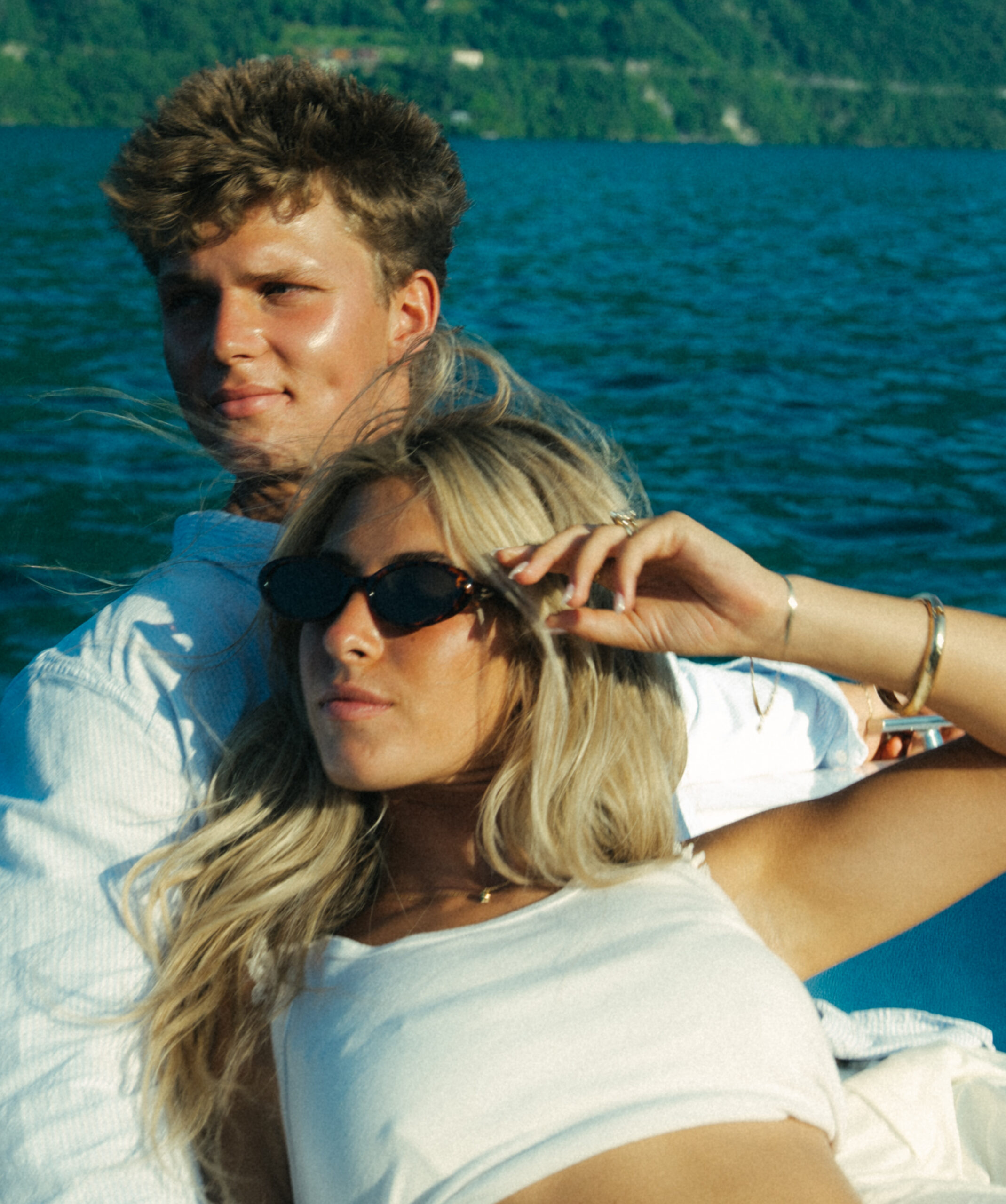 A cinematic photo of a couple posing in a boat in Lake Como.