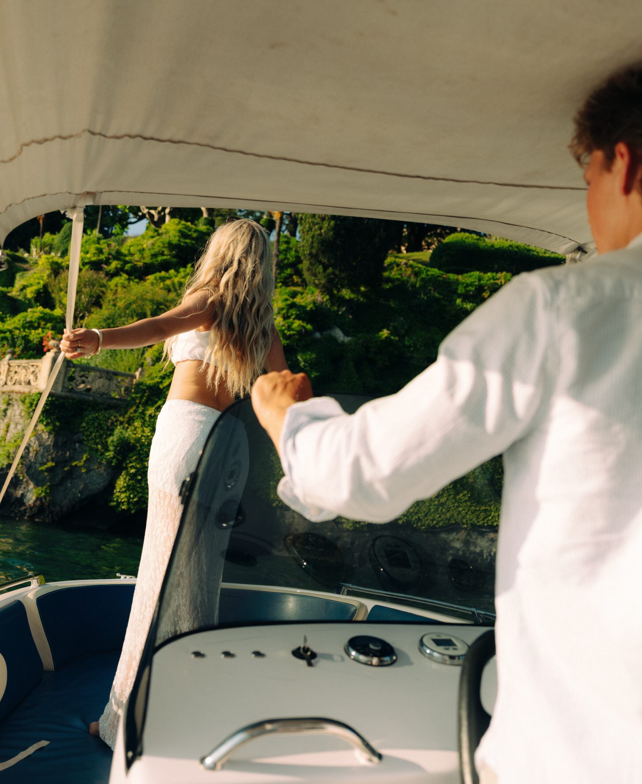 A cinematic photo of a couple posing in a boat in Lake Como.