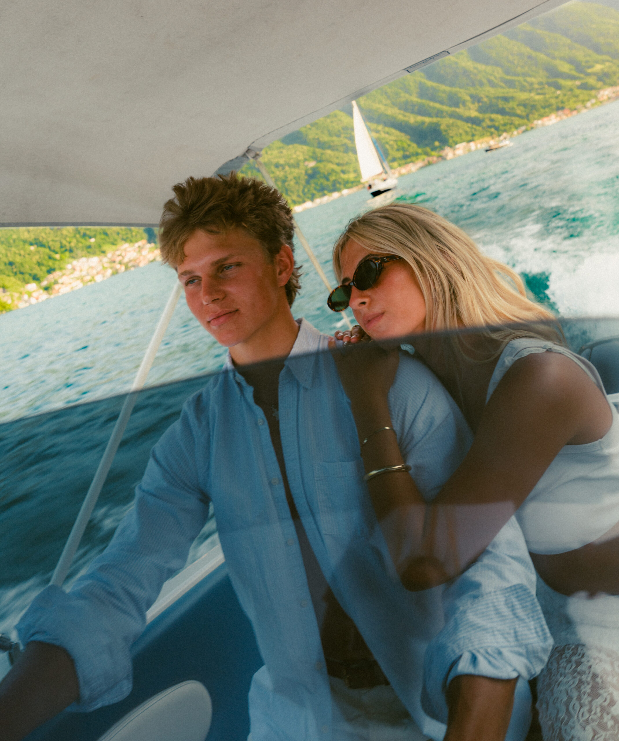 A cinematic photo of a couple posing in a boat in Lake Como.