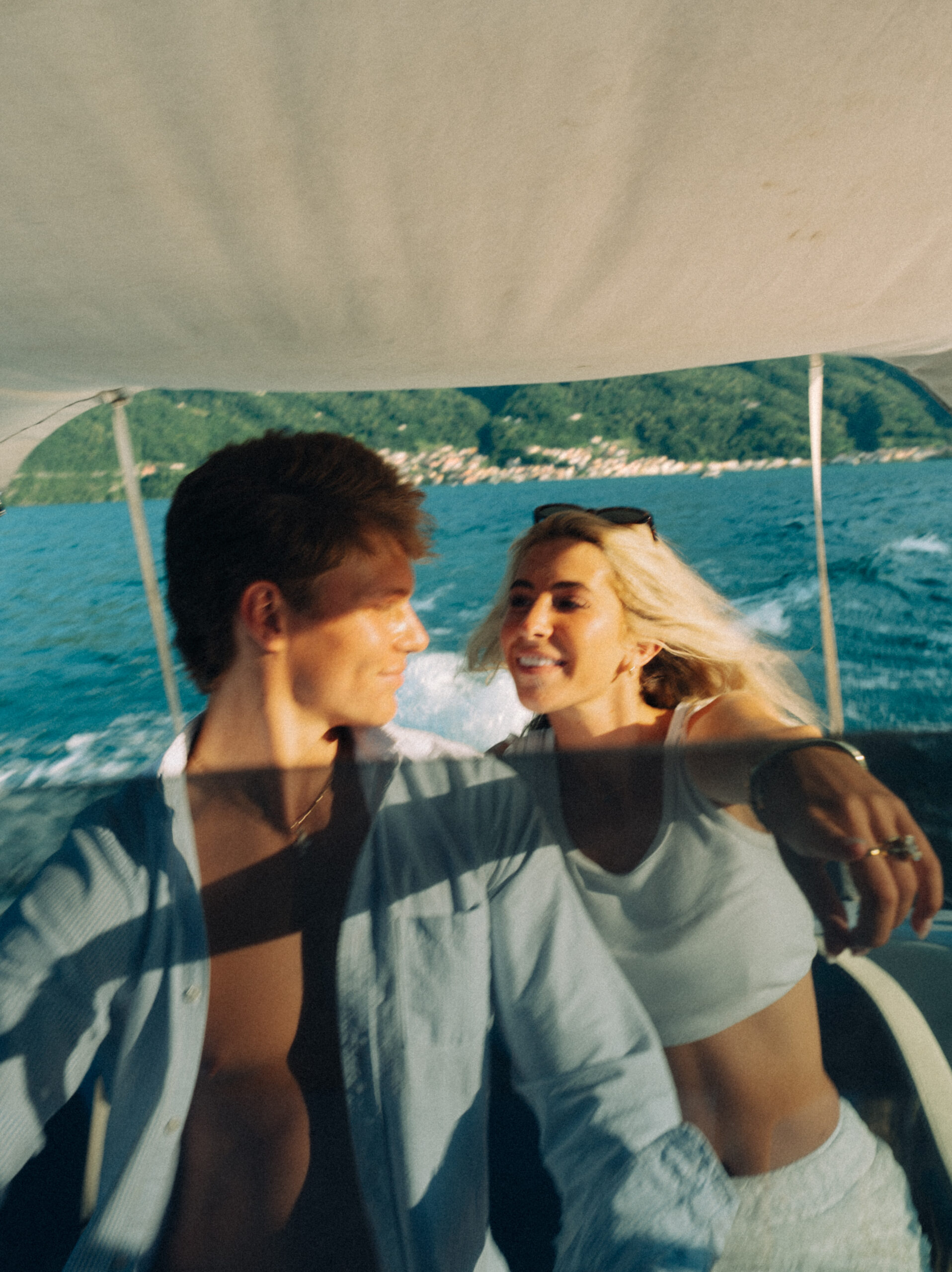 A cinematic photo of a couple posing in a boat in Lake Como.