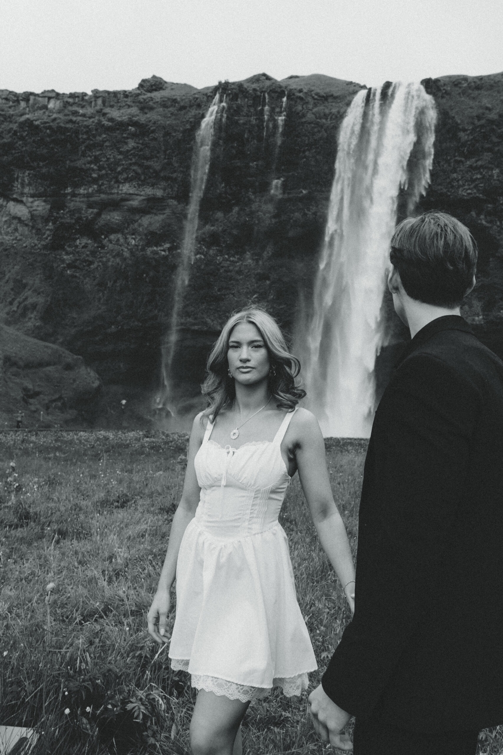 A cinematic photo of a couple in front of a waterfall during their elopement in Iceland.