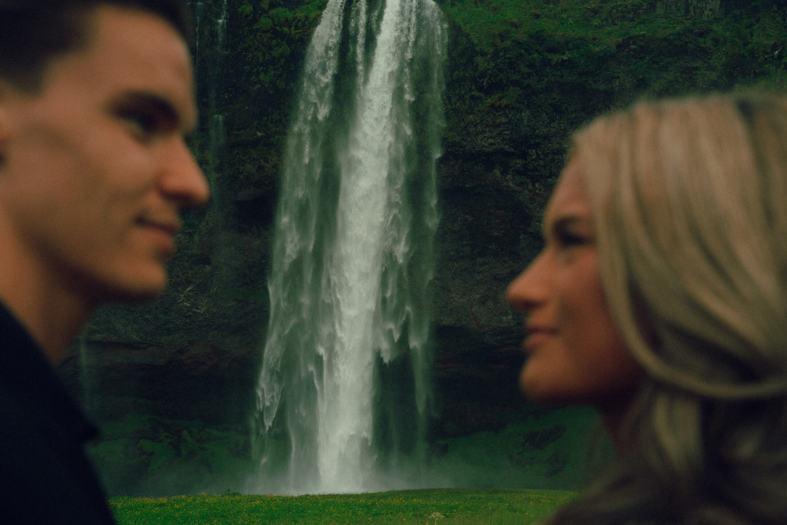 A cinematic photo of a couple in front of a waterfall during their elopement in Iceland.