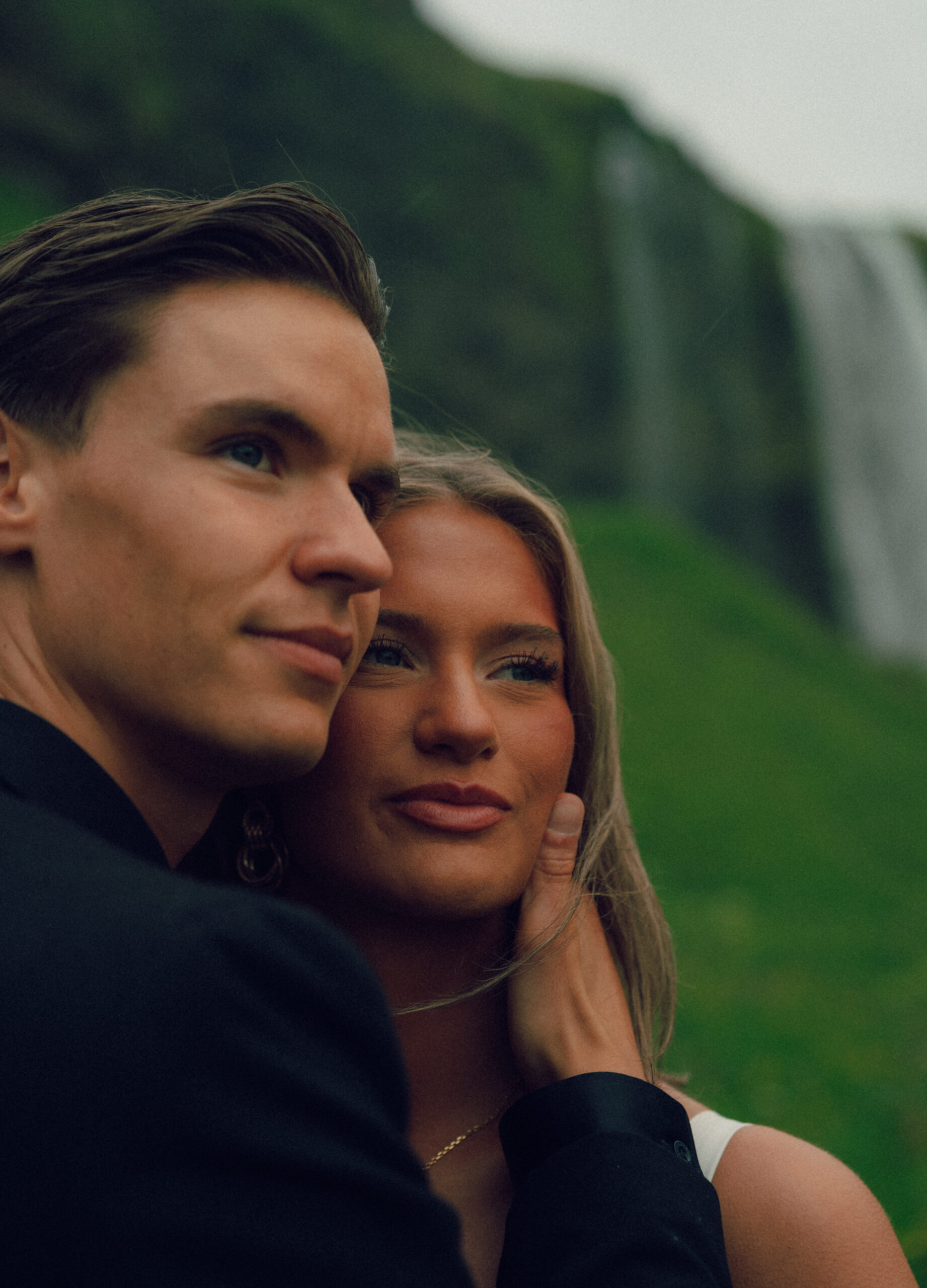 A cinematic photo of a couple in front of a waterfall during their elopement in Iceland.