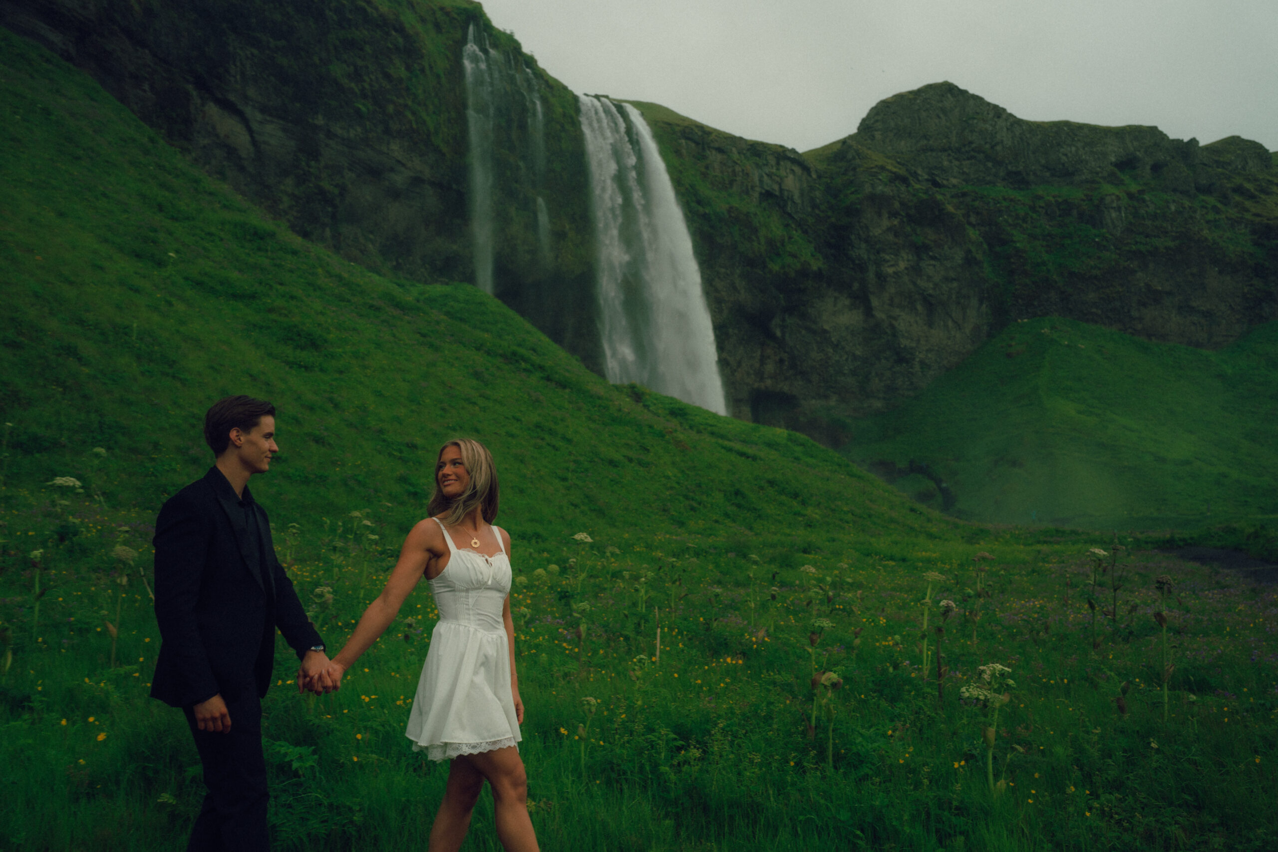 A cinematic photo of a couple in front of a waterfall during their elopement in Iceland.