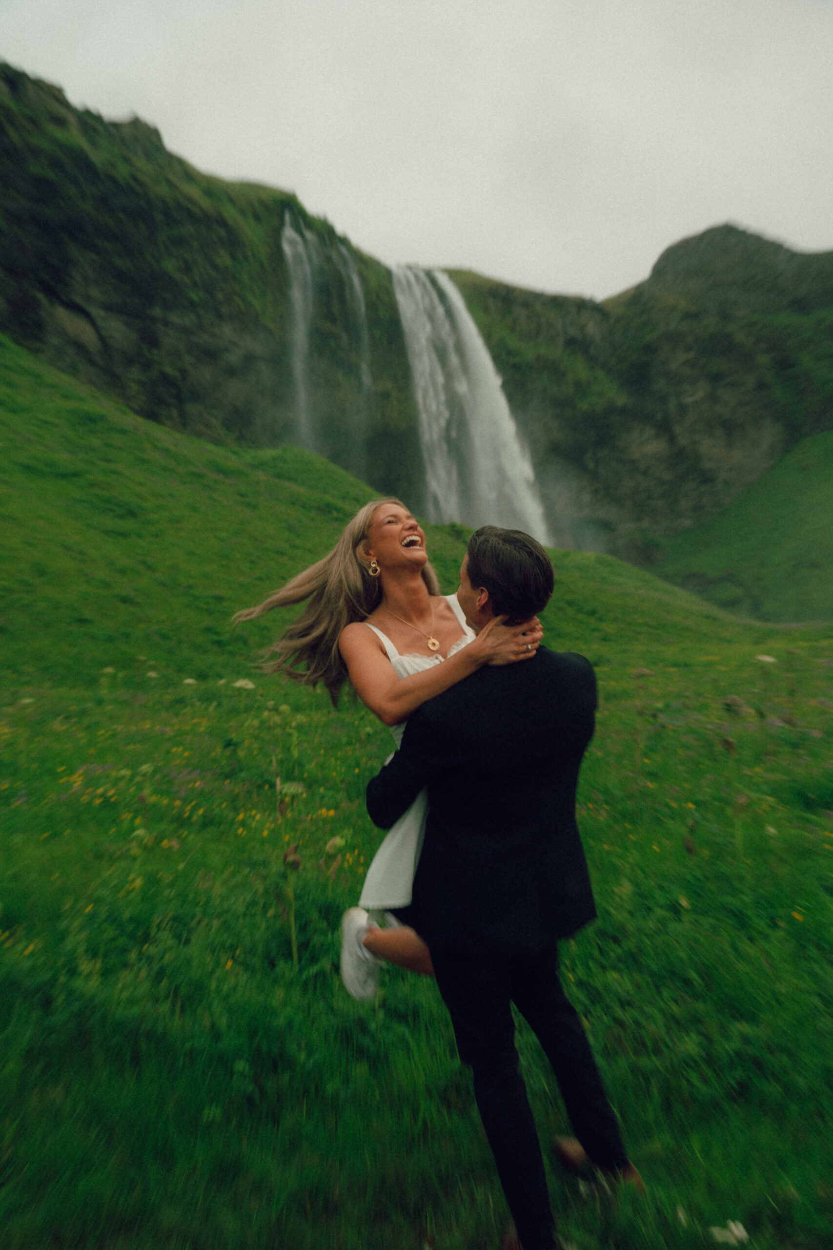 A cinematic photo of a couple in front of a waterfall during their elopement in Iceland.
