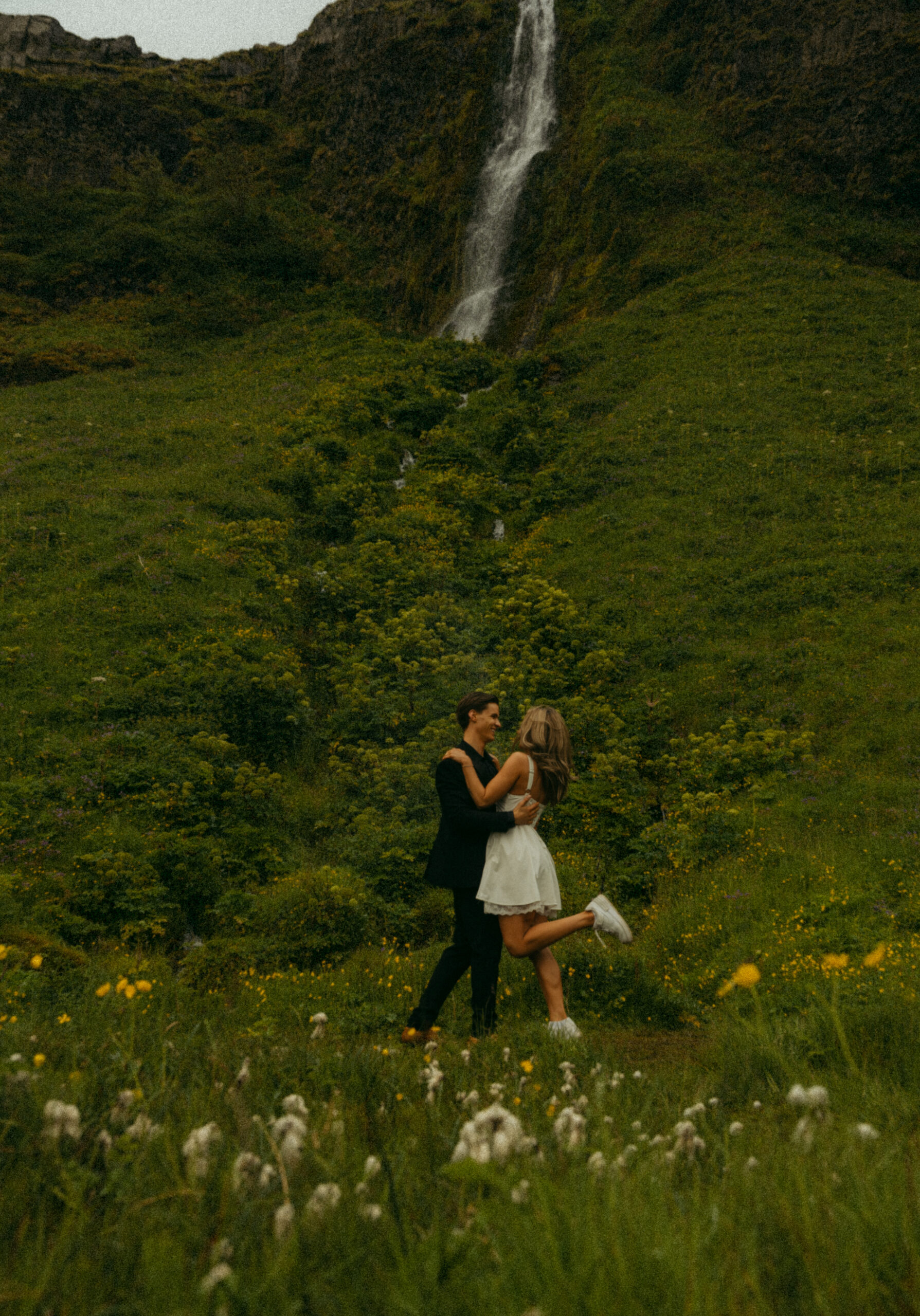 A cinematic photo of a couple in front of a waterfall during their elopement in Iceland.