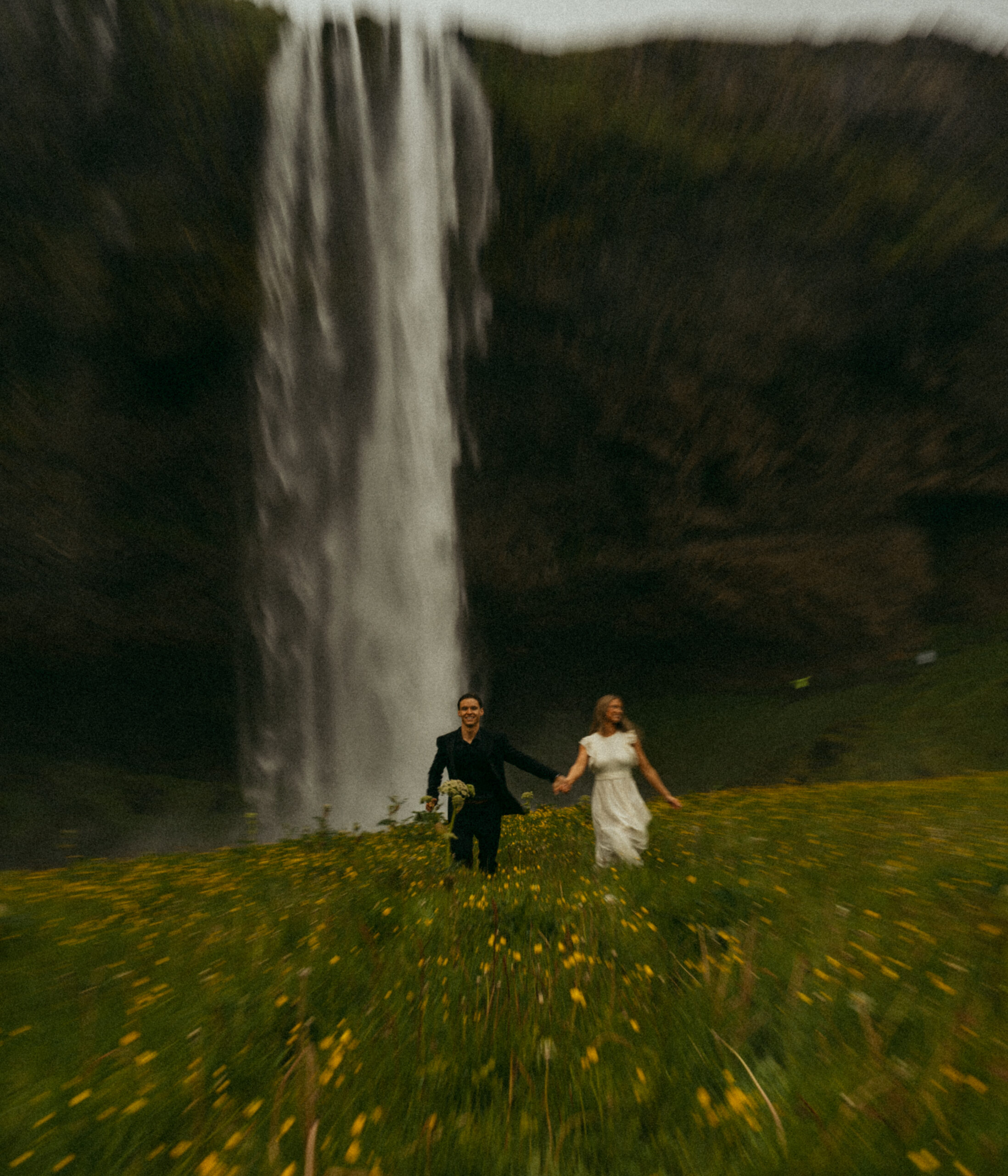 A cinematic photo of a couple in front of a waterfall during their elopement in Iceland.