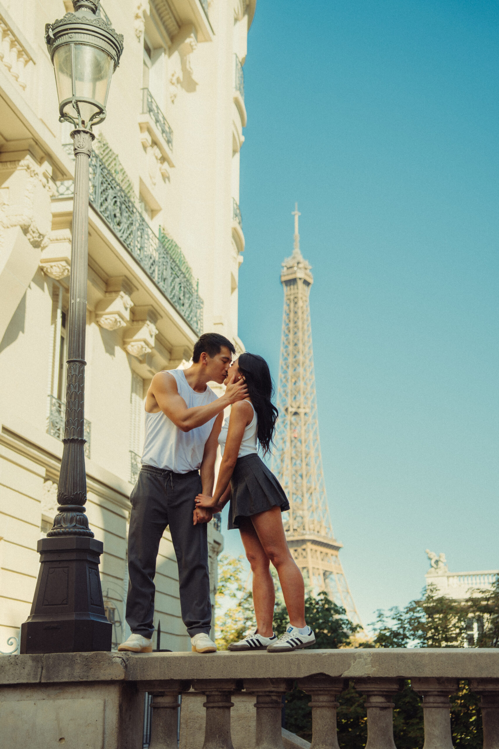 A cinematic photo of a couple posing in Paris with the Eiffel Tower in the background.