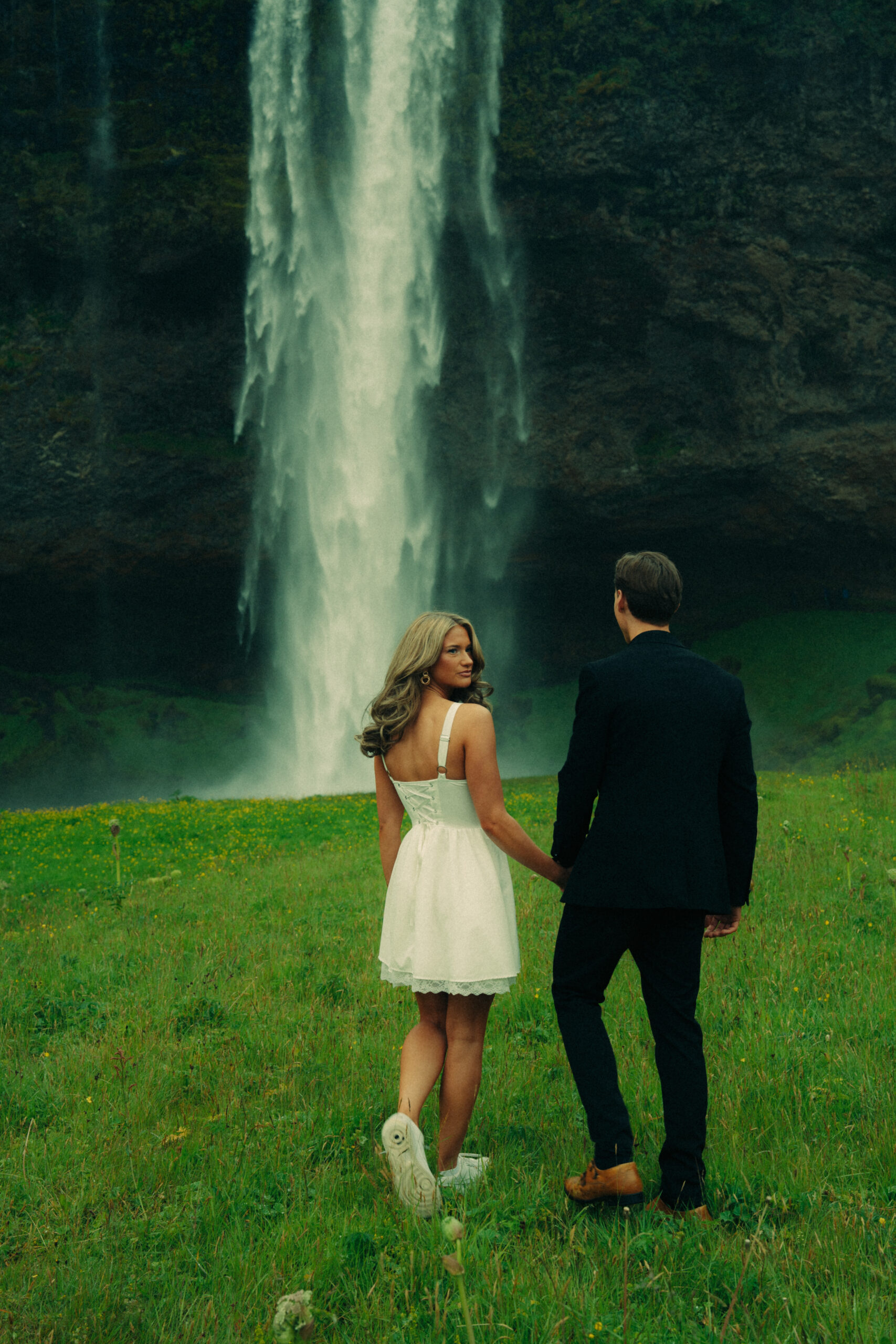 A cinematic photo of a couple in front of a waterfall during their elopement in Iceland.