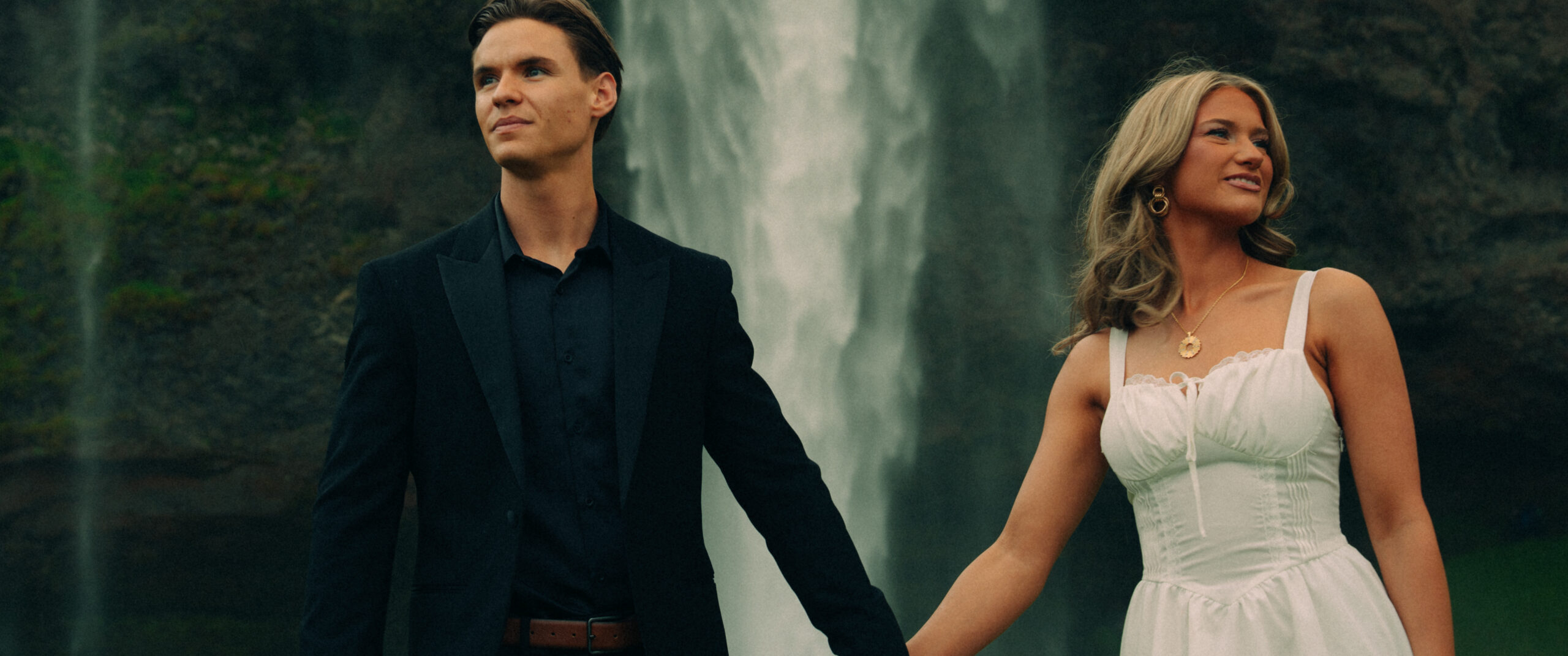 A cinematic photo of a couple in front of a waterfall during their elopement in Iceland.
