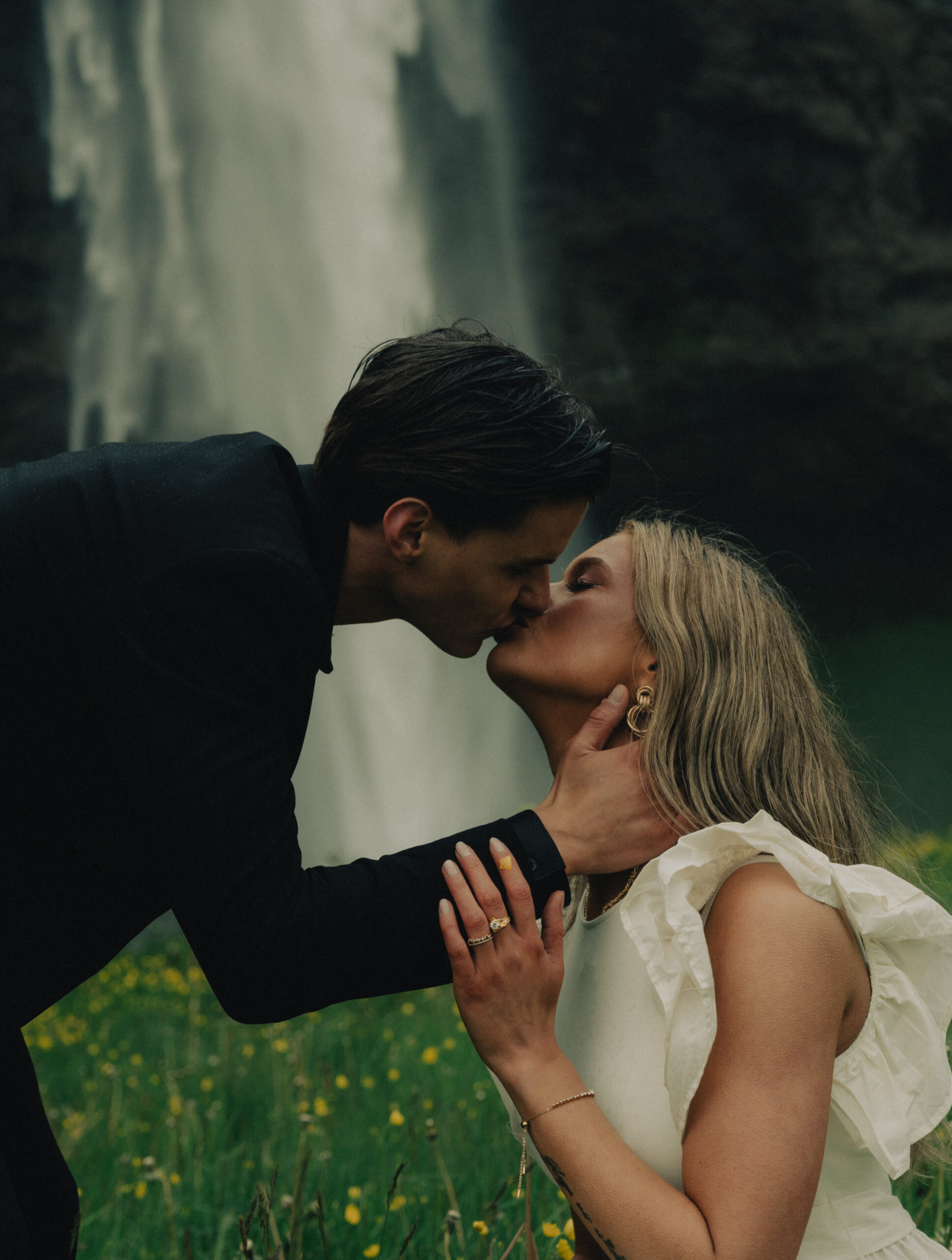 A cinematic photo of a couple in front of a waterfall during their elopement in Iceland.