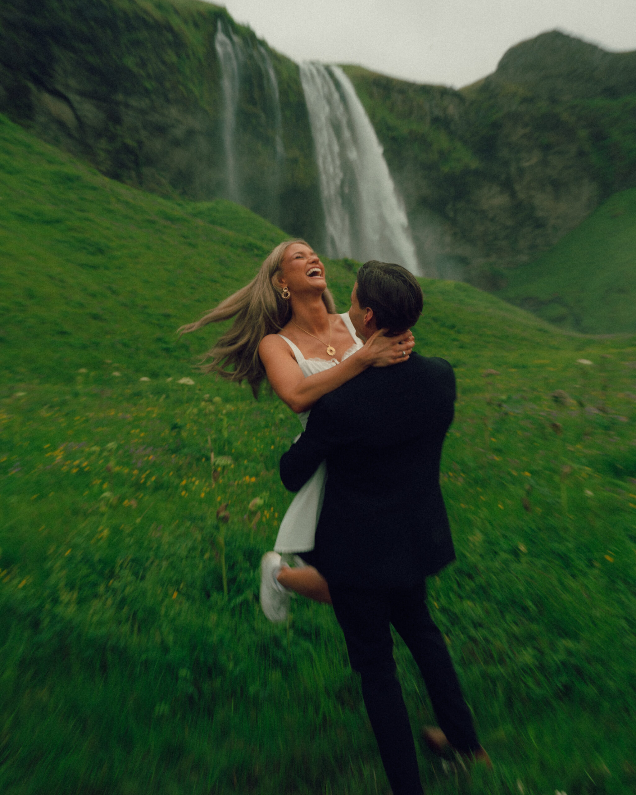 A cinematic photo of a couple in front of a waterfall during their elopement in Iceland.