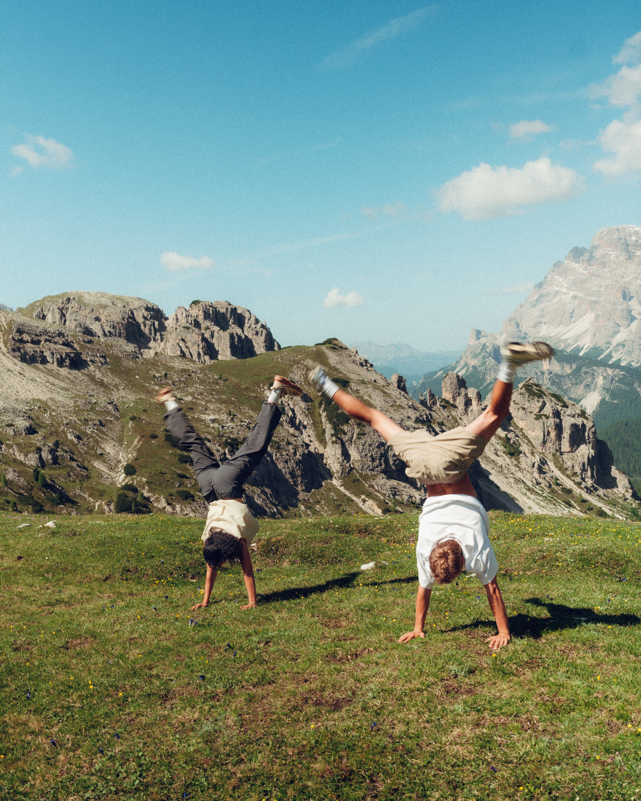 A cinematic photo of a couple posing with the Dolomites in the background.