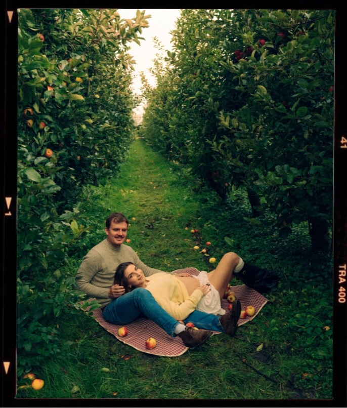 A cinematic photo of a couple at an apple orchard in the Netherlands.