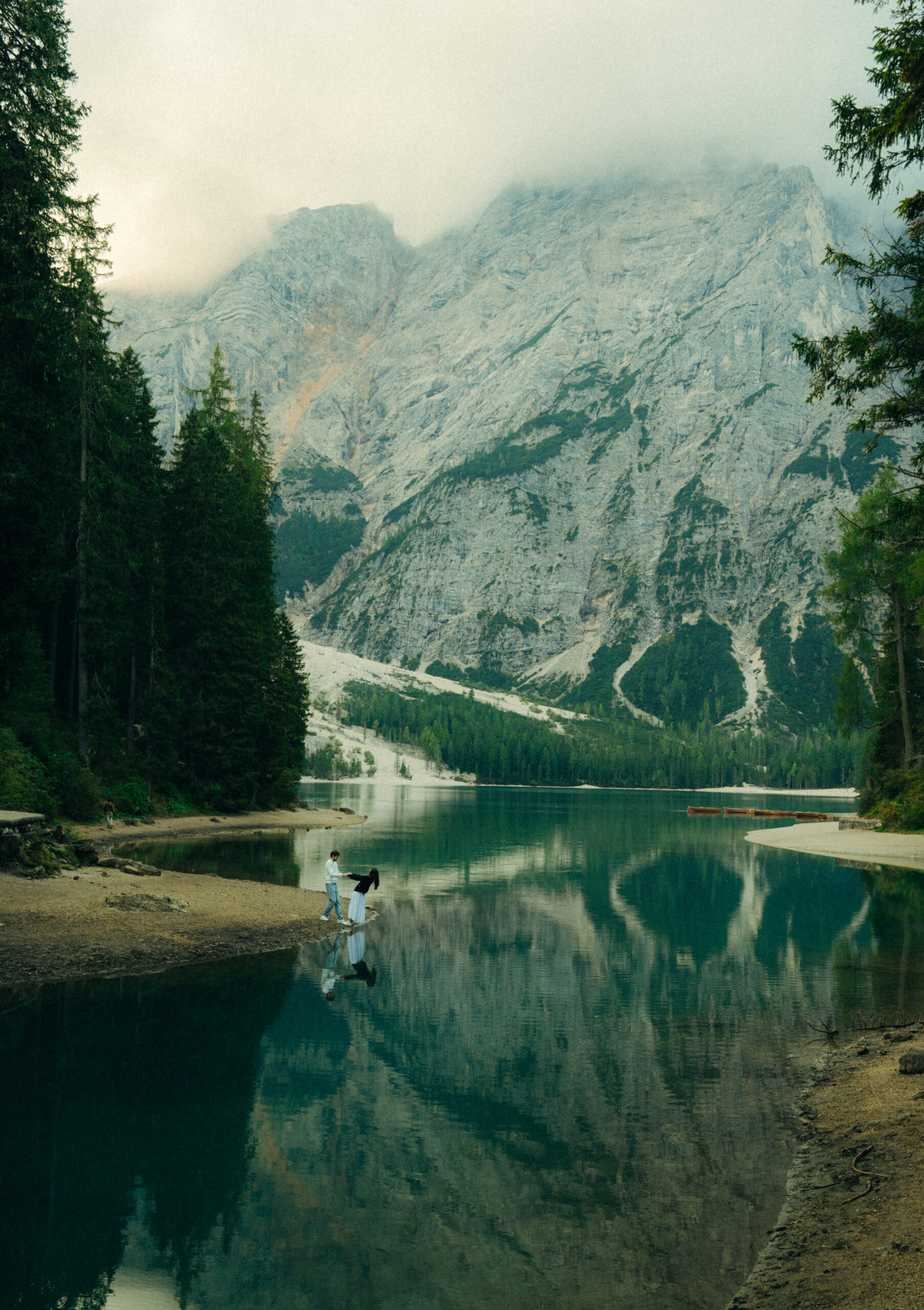 A cinematic photo of a couple in Lake Braies in Italy.