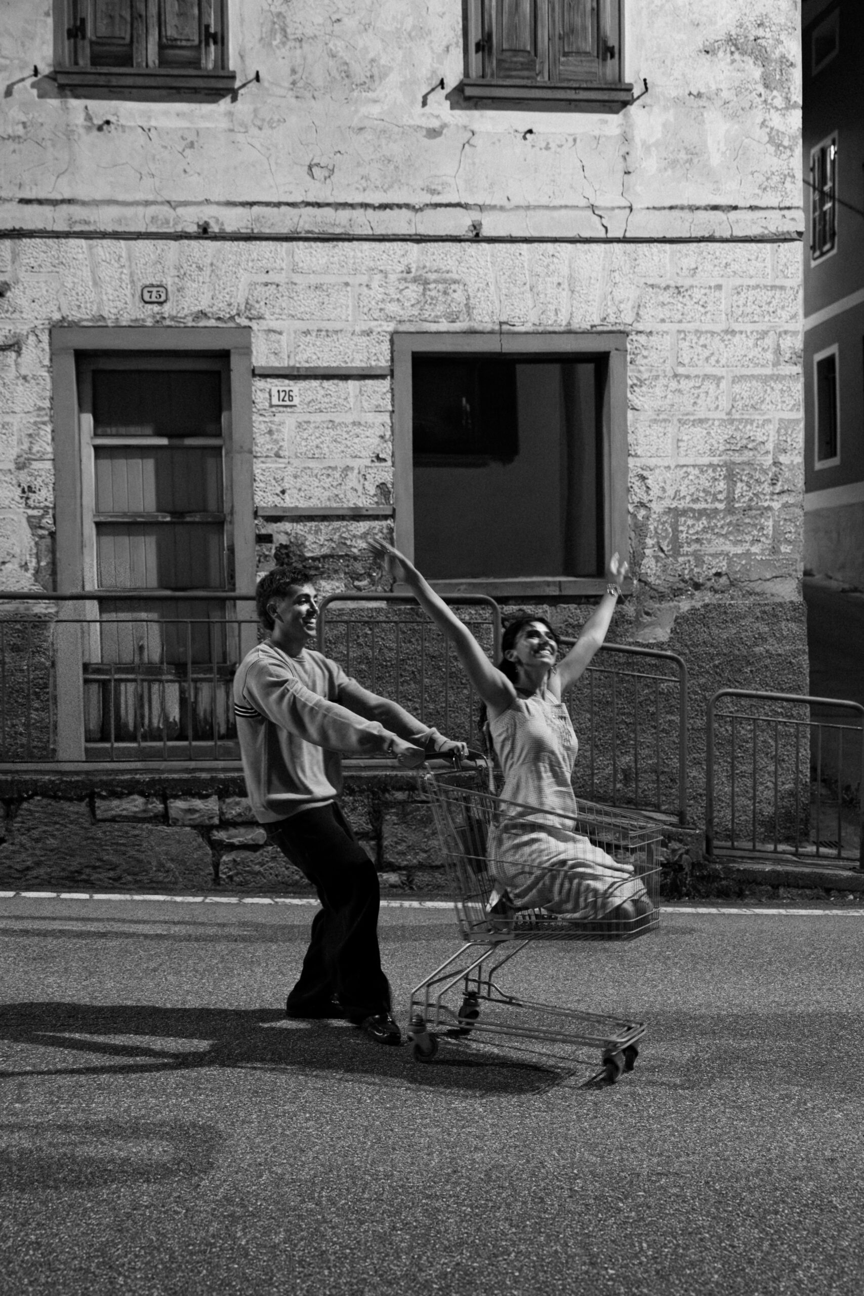 A cinematic photo of a couple posing in the streets of Italy at night.