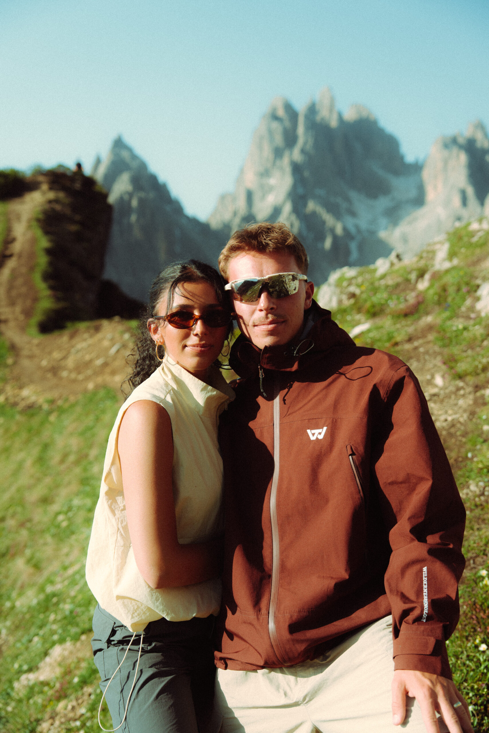 A cinematic photo of a couple posing with the Dolomites in the background.