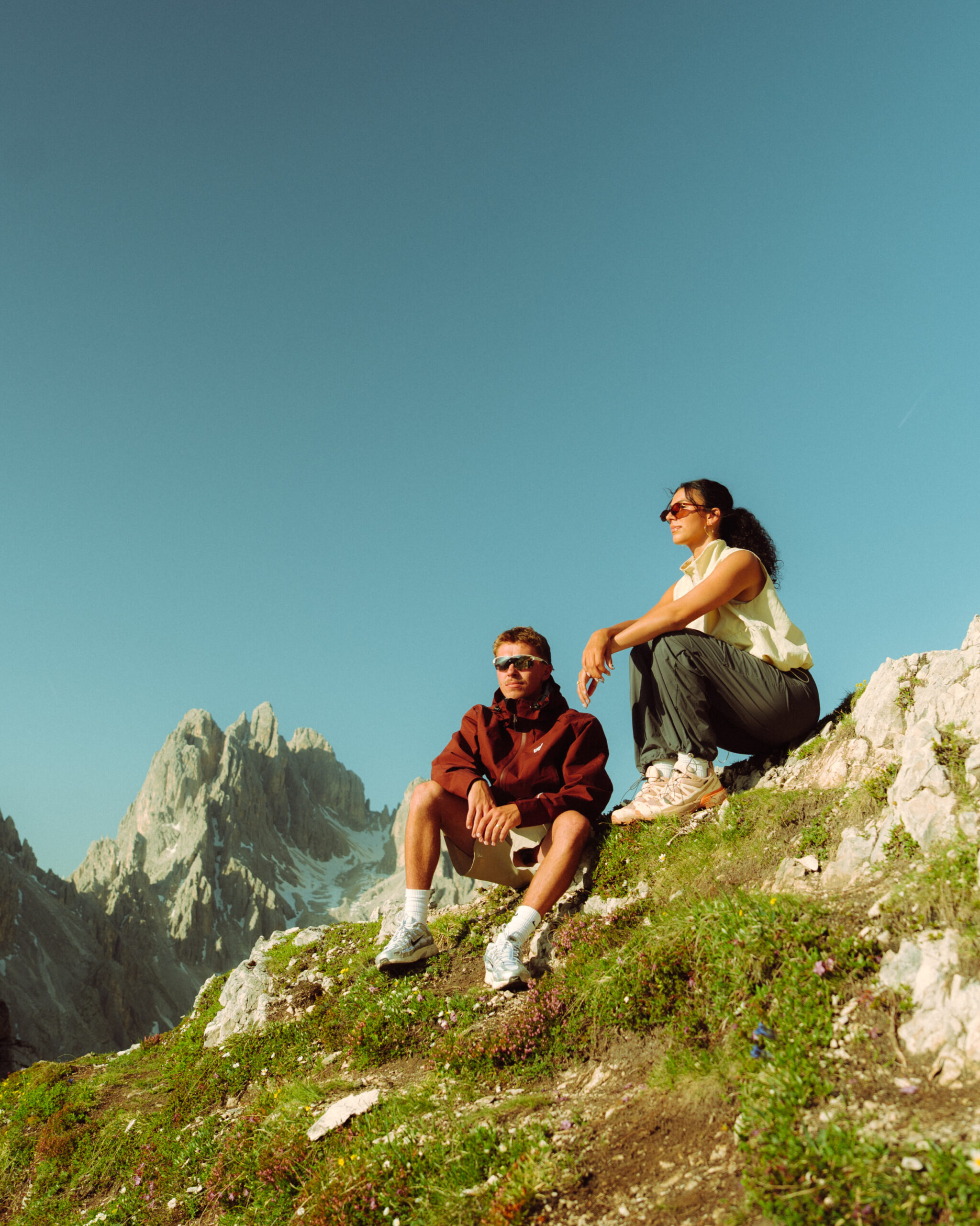 A cinematic photo of a couple posing with the Dolomites in the background.