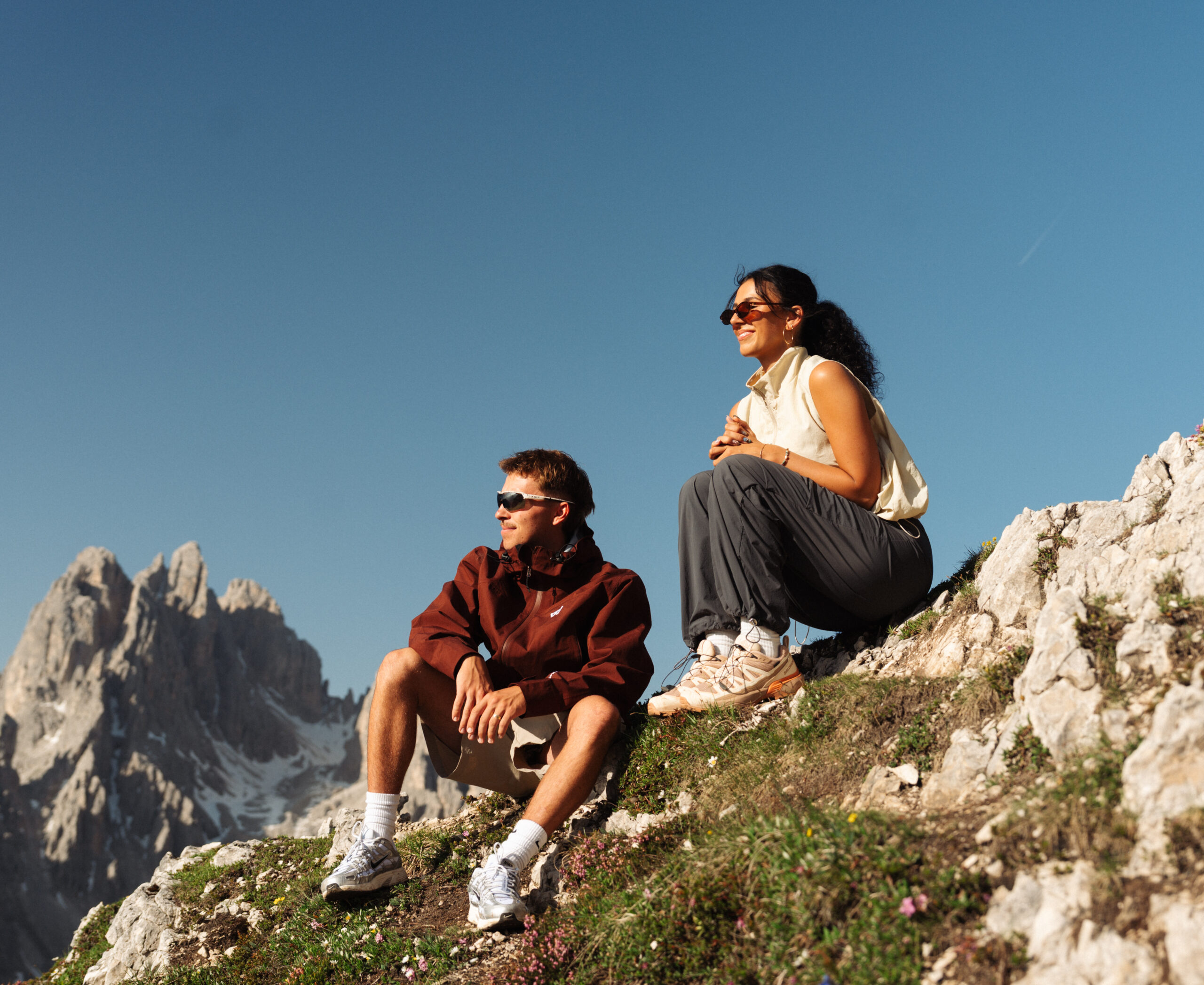 A cinematic photo of a couple posing with the Dolomites in the background.