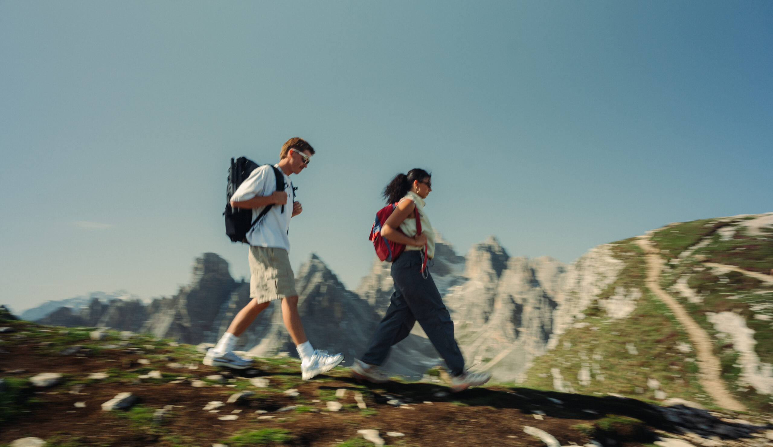 A cinematic photo of a couple posing with the Dolomites in the background.