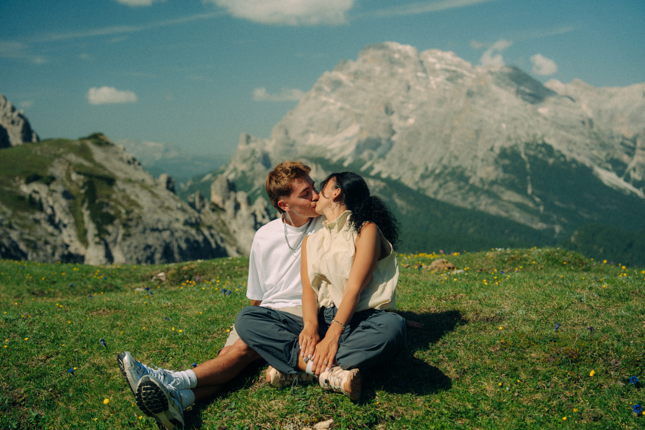 A cinematic photo of a couple posing with the Dolomites in the background.