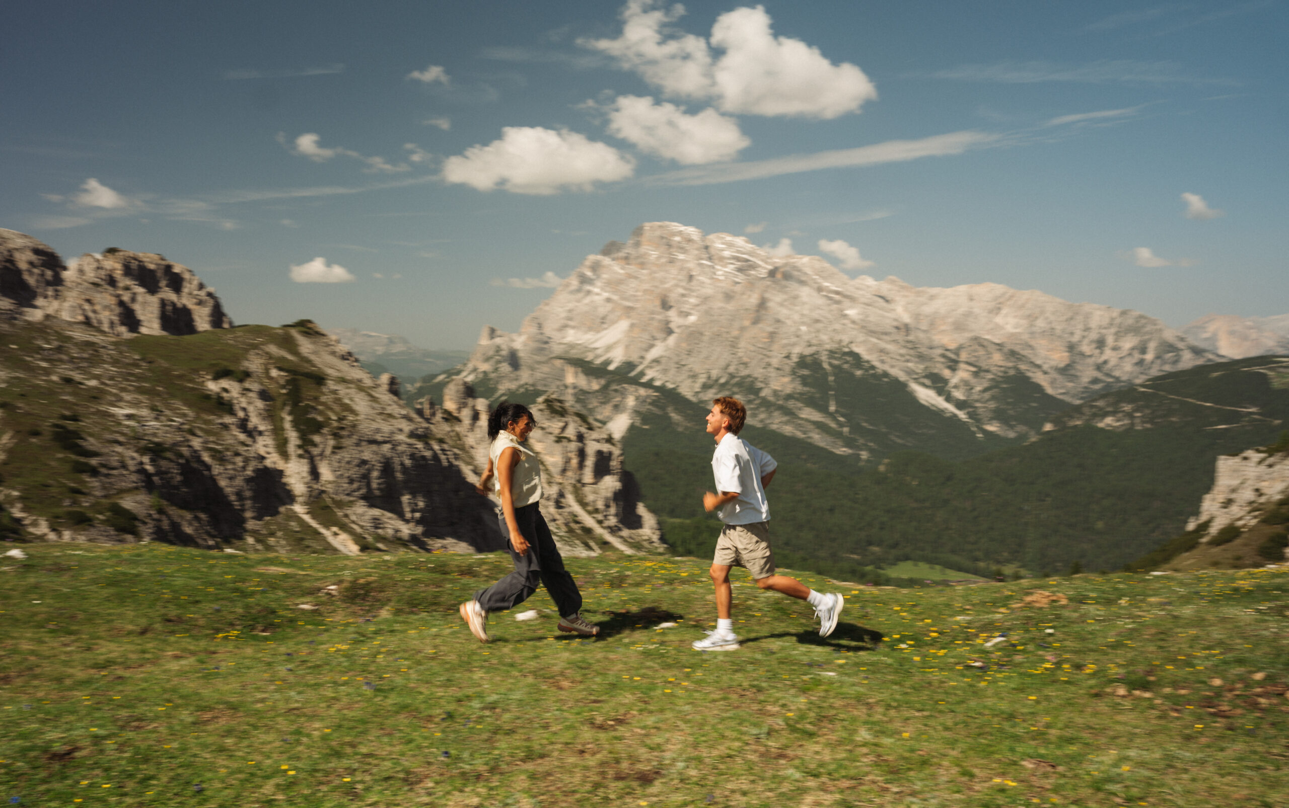 A cinematic photo of a couple posing with the Dolomites in the background.