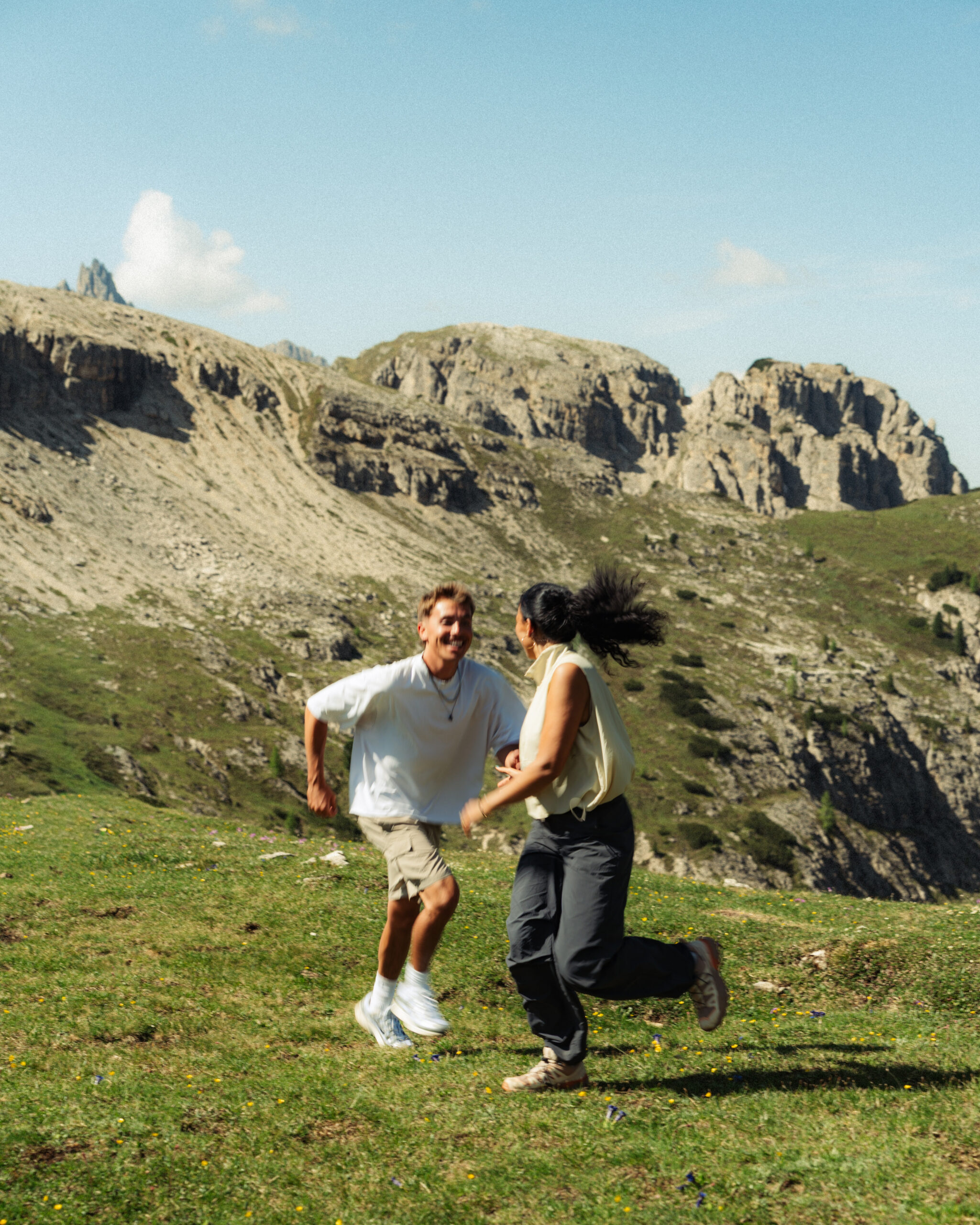 A cinematic photo of a couple posing with the Dolomites in the background.