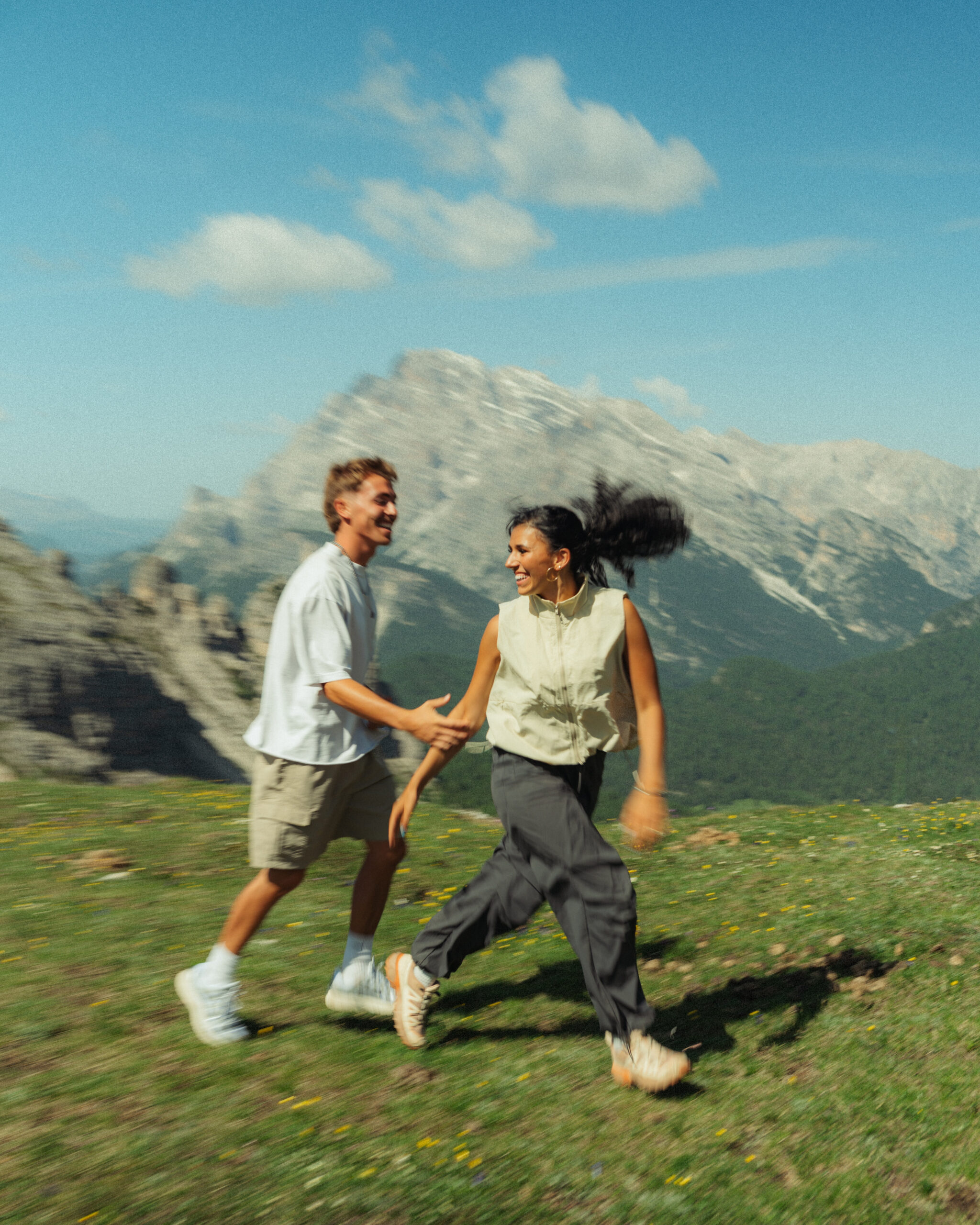 A cinematic photo of a couple posing with the Dolomites in the background.