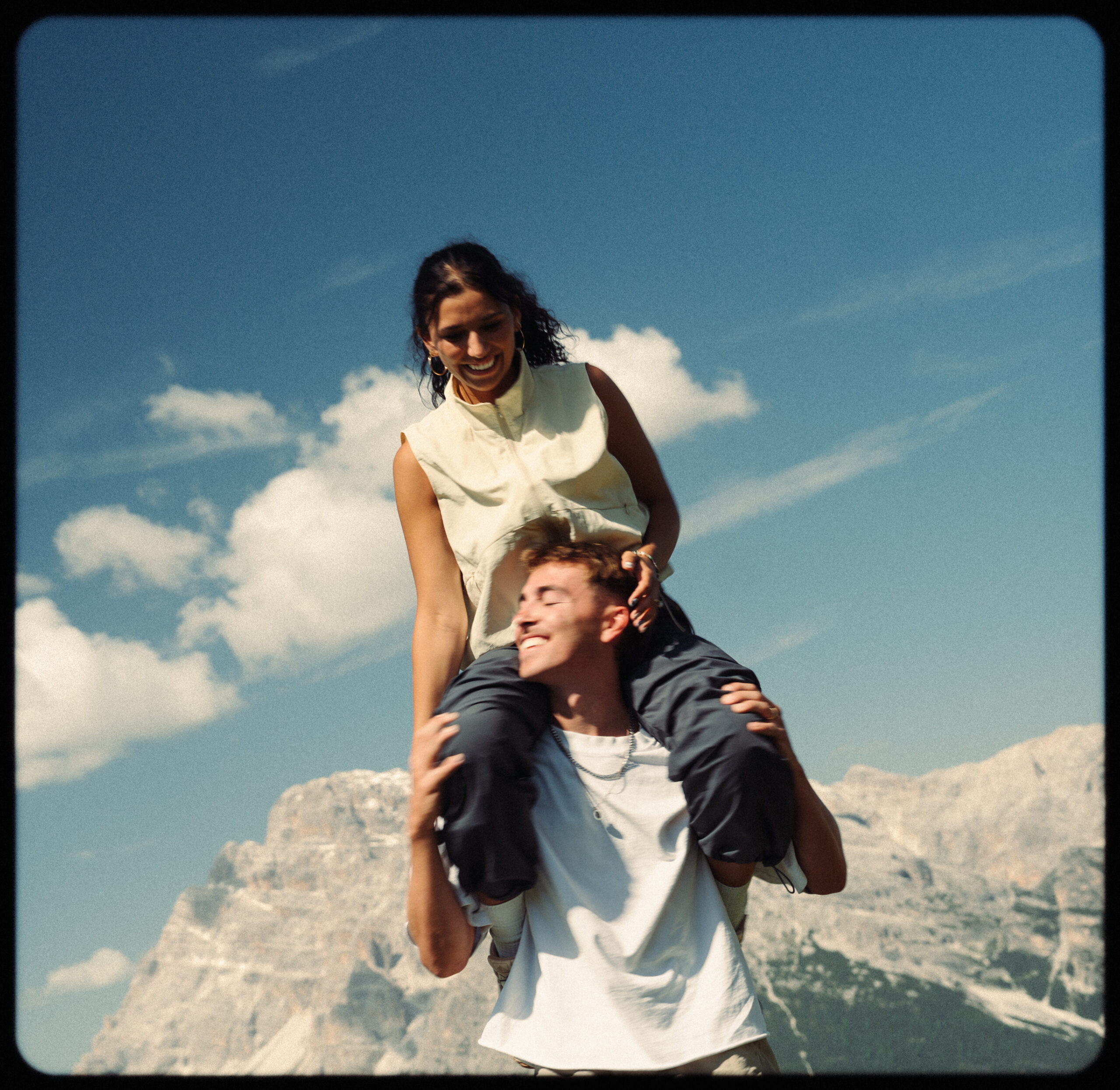 A cinematic photo of a couple posing with the Dolomites in the background.