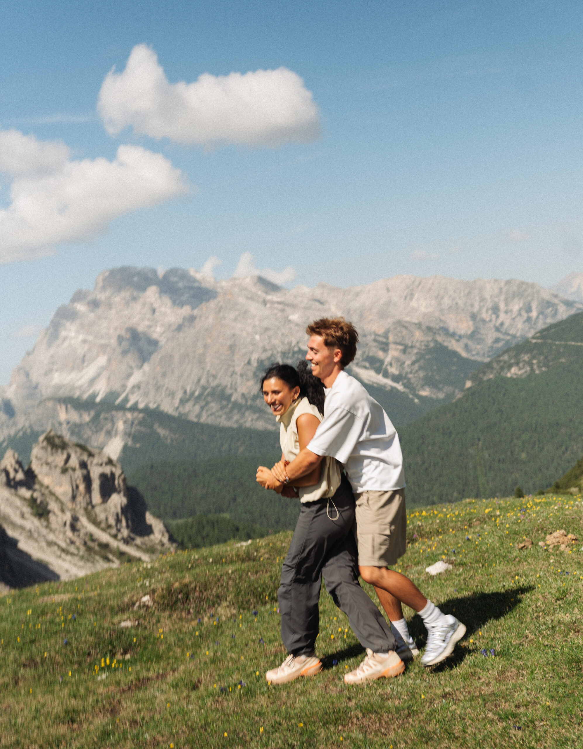 A cinematic photo of a couple posing with the Dolomites in the background.