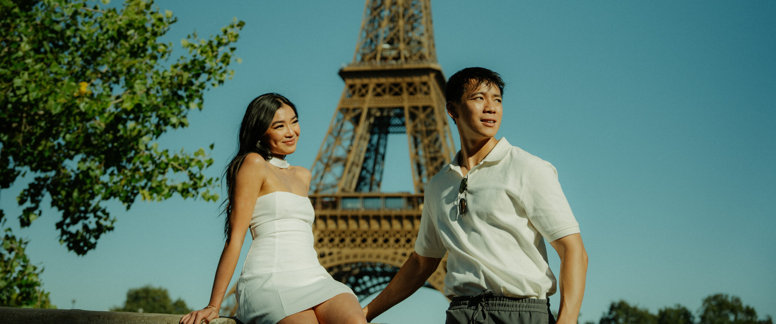 A cinematic photo of a couple posing in Paris with the Eiffel Tower in the background.