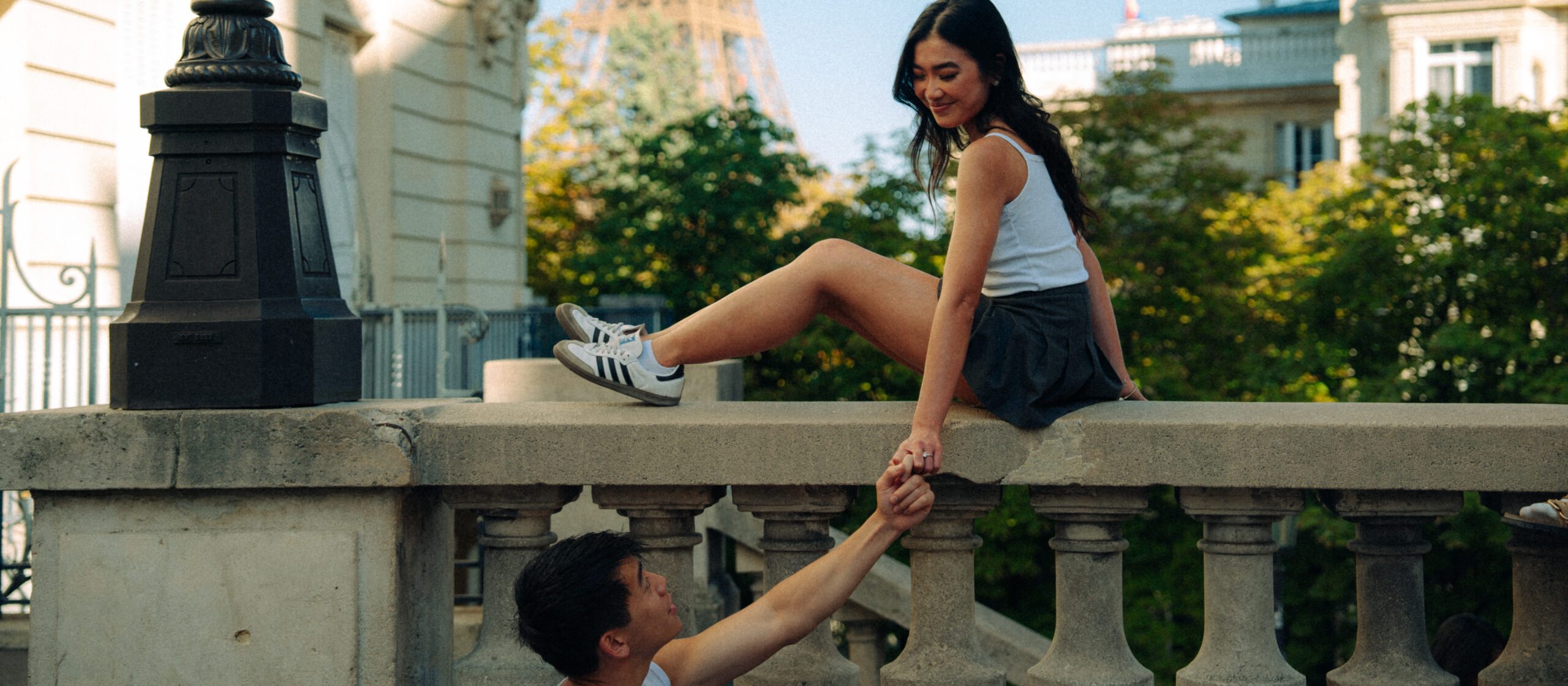 A cinematic photo of a couple posing in Paris with the Eiffel Tower in the background.