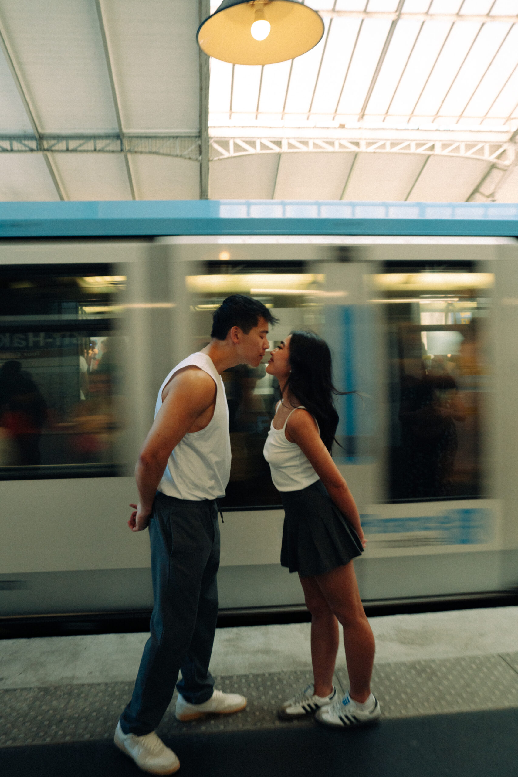 A cinematic photo of a couple posing in Paris metro.