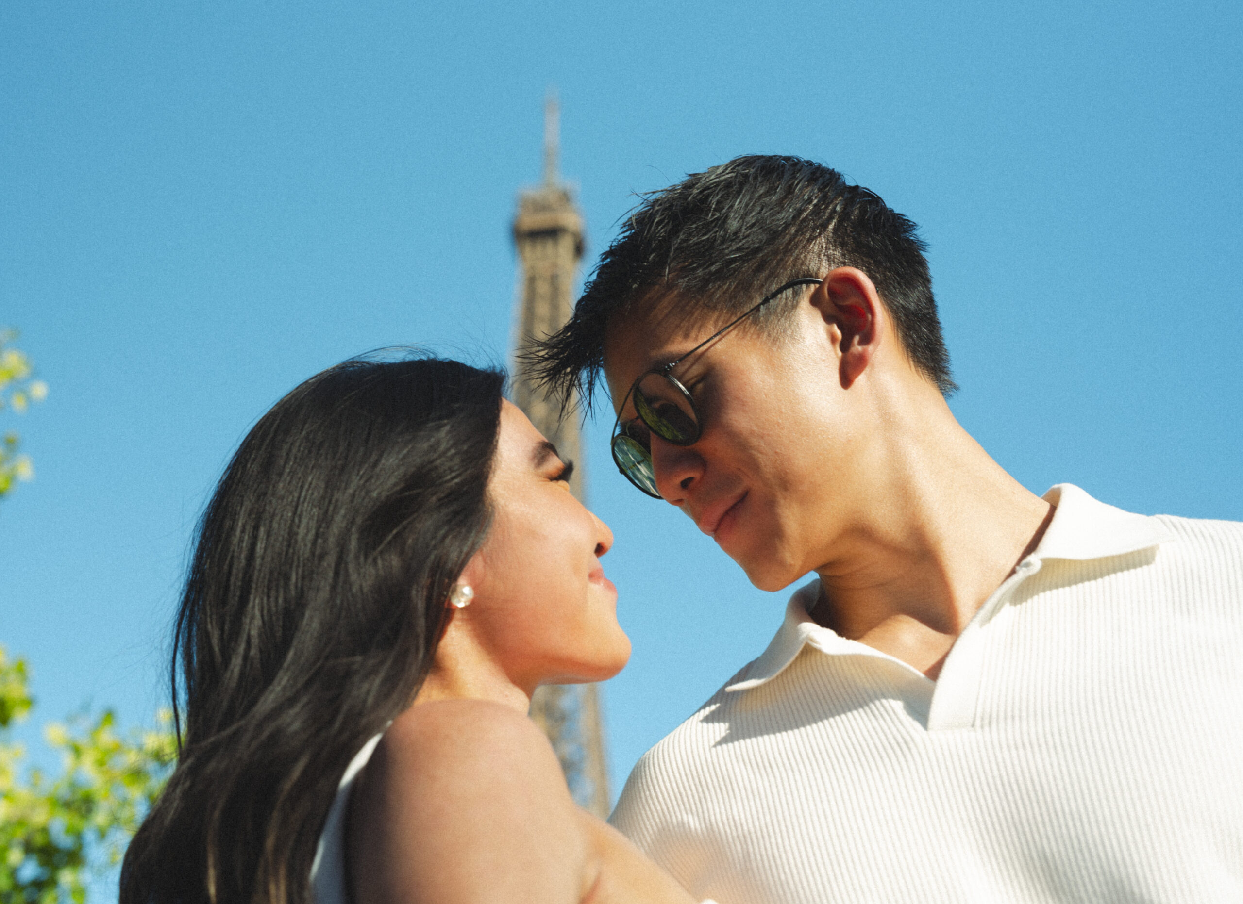 A cinematic photo of a couple posing in Paris with the Eiffel Tower in the background.