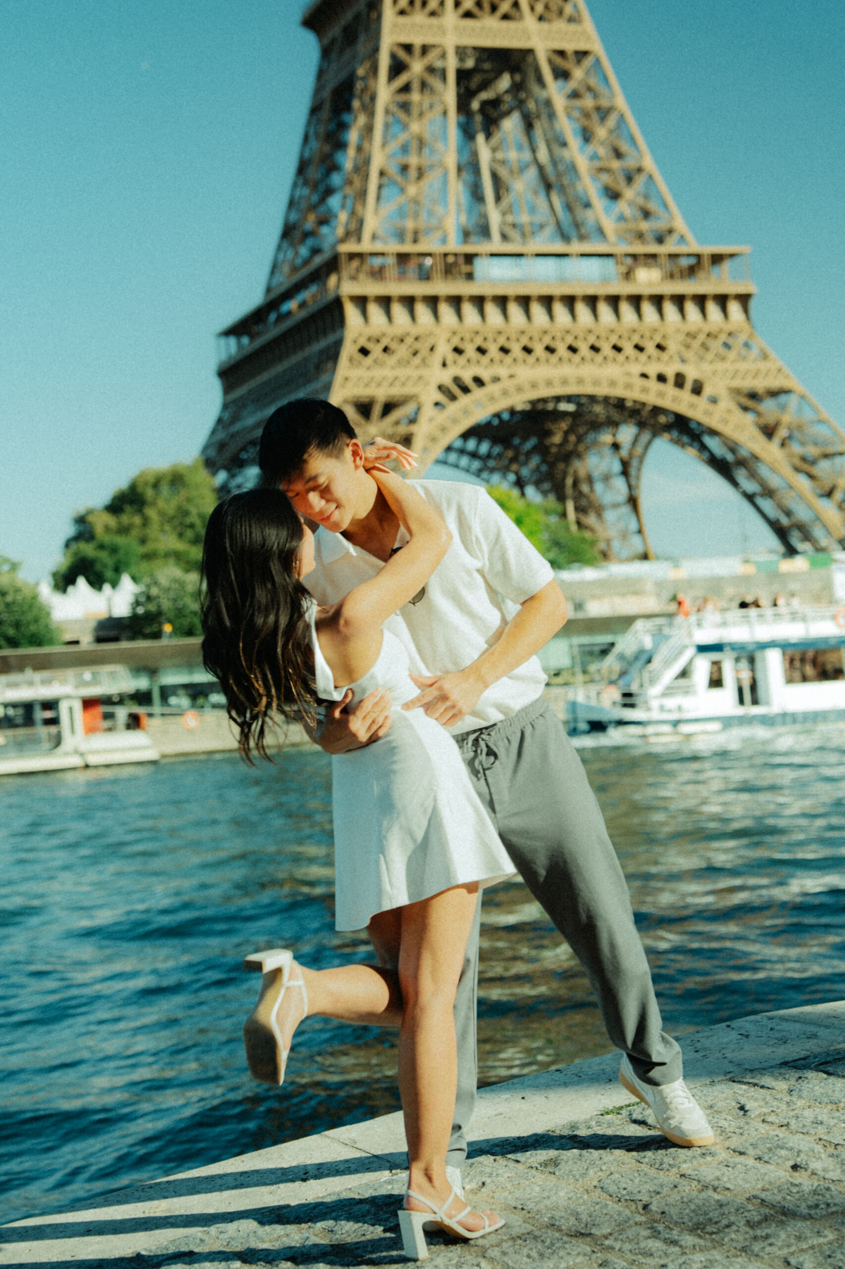 A cinematic photo of a couple posing in Paris with the Eiffel Tower in the background.