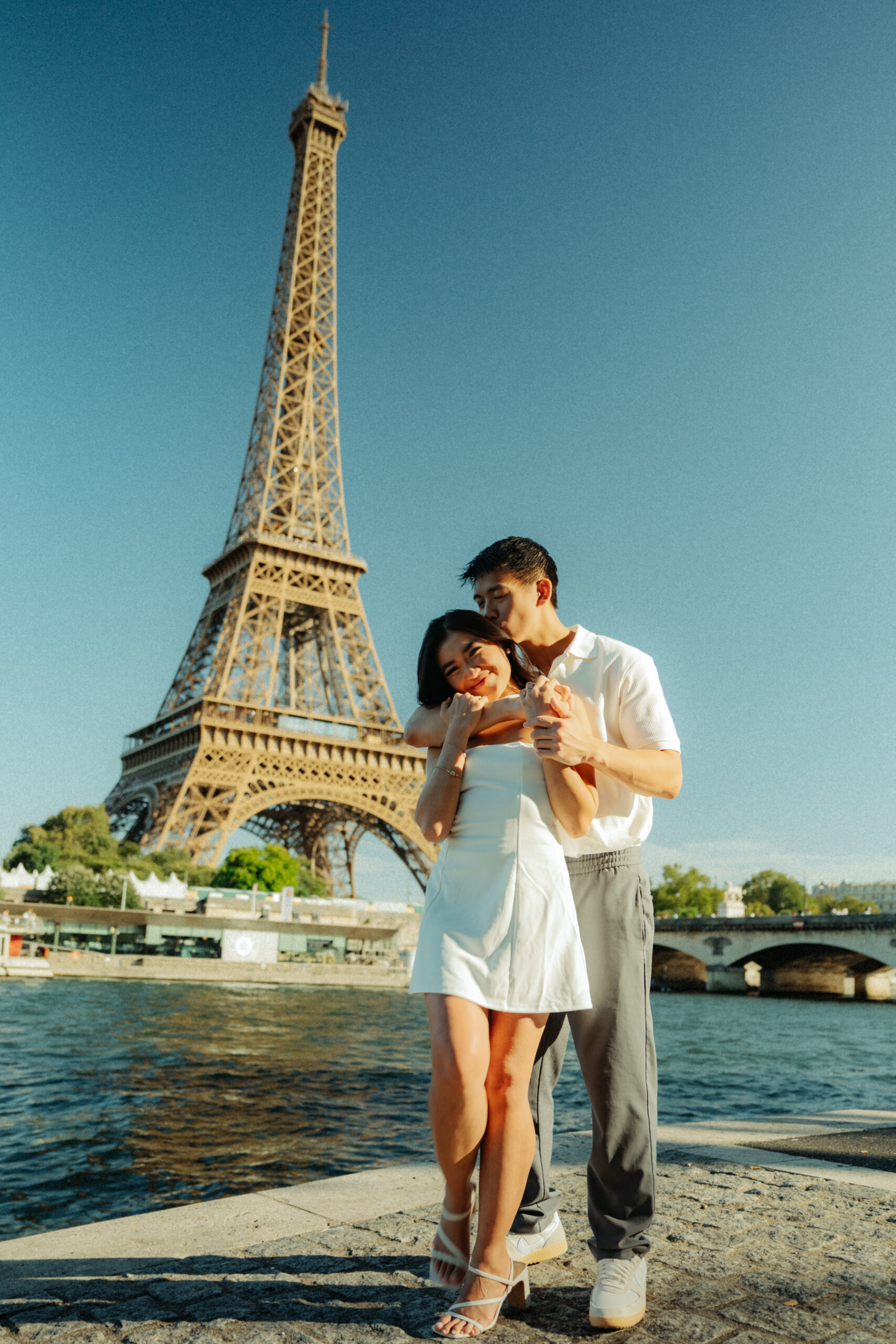 A cinematic photo of a couple posing in Paris with the Eiffel Tower in the background.