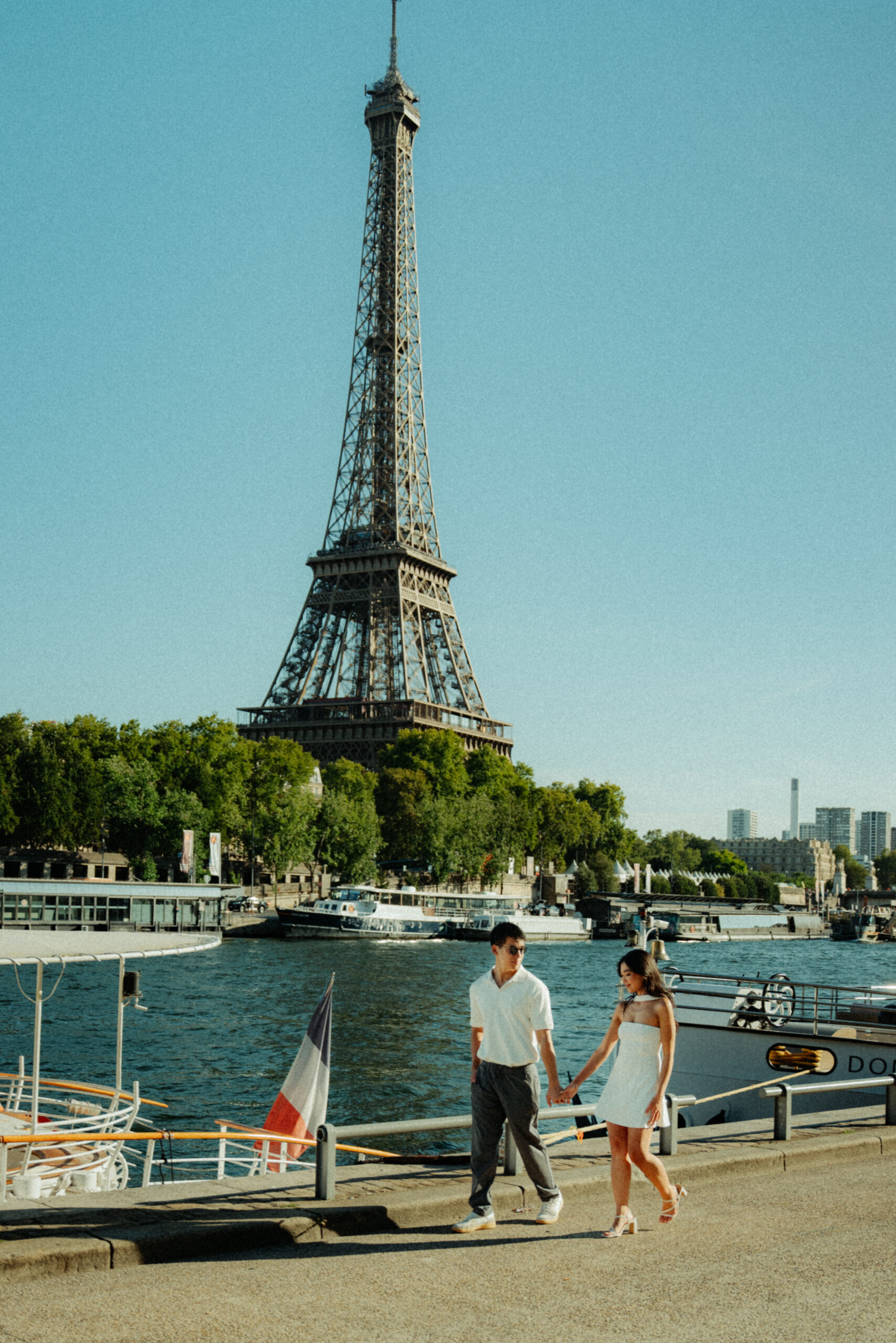 A cinematic photo of a couple posing in Paris with the Eiffel Tower in the background.