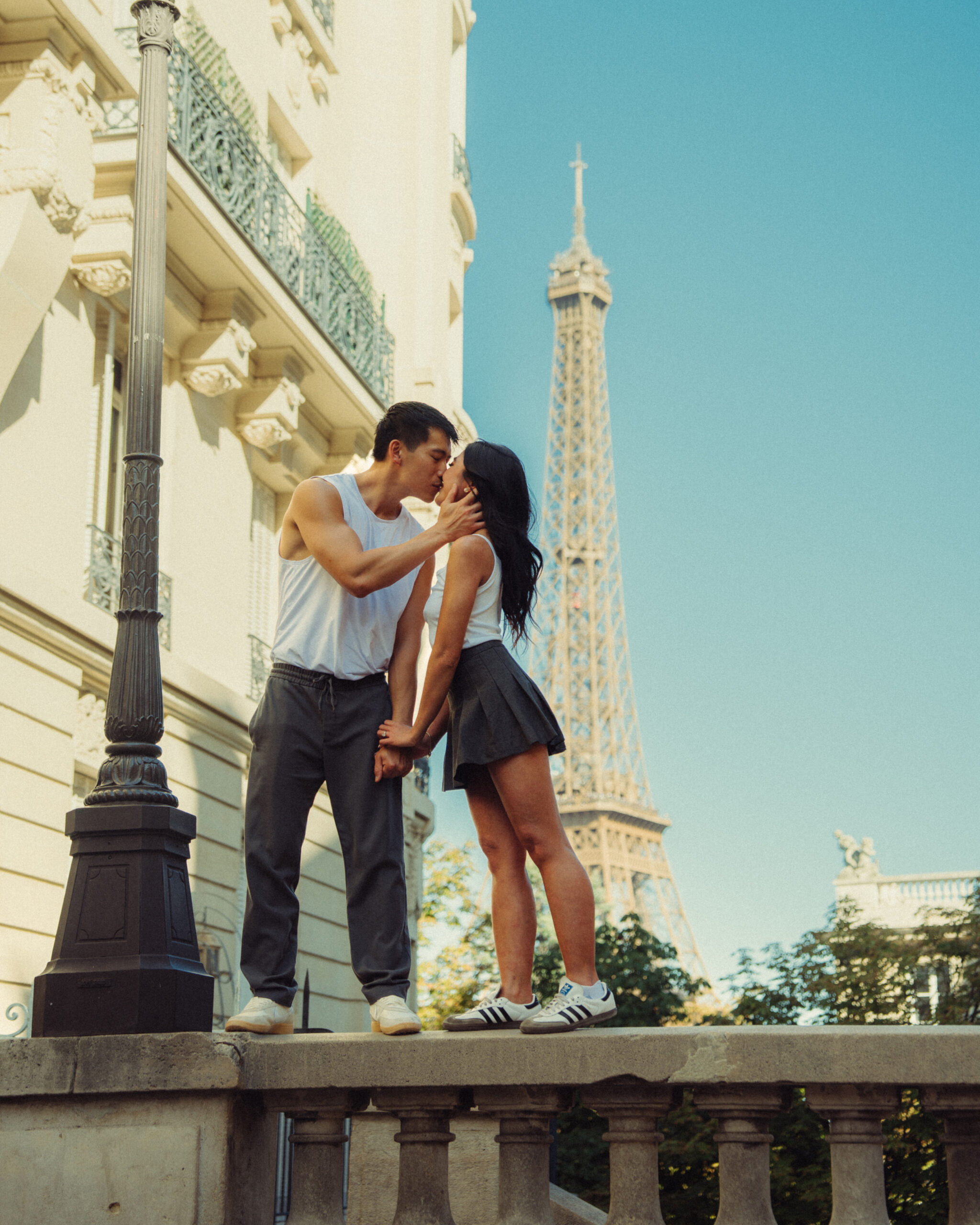A cinematic photo of a couple posing in Paris with the Eiffel Tower in the background.