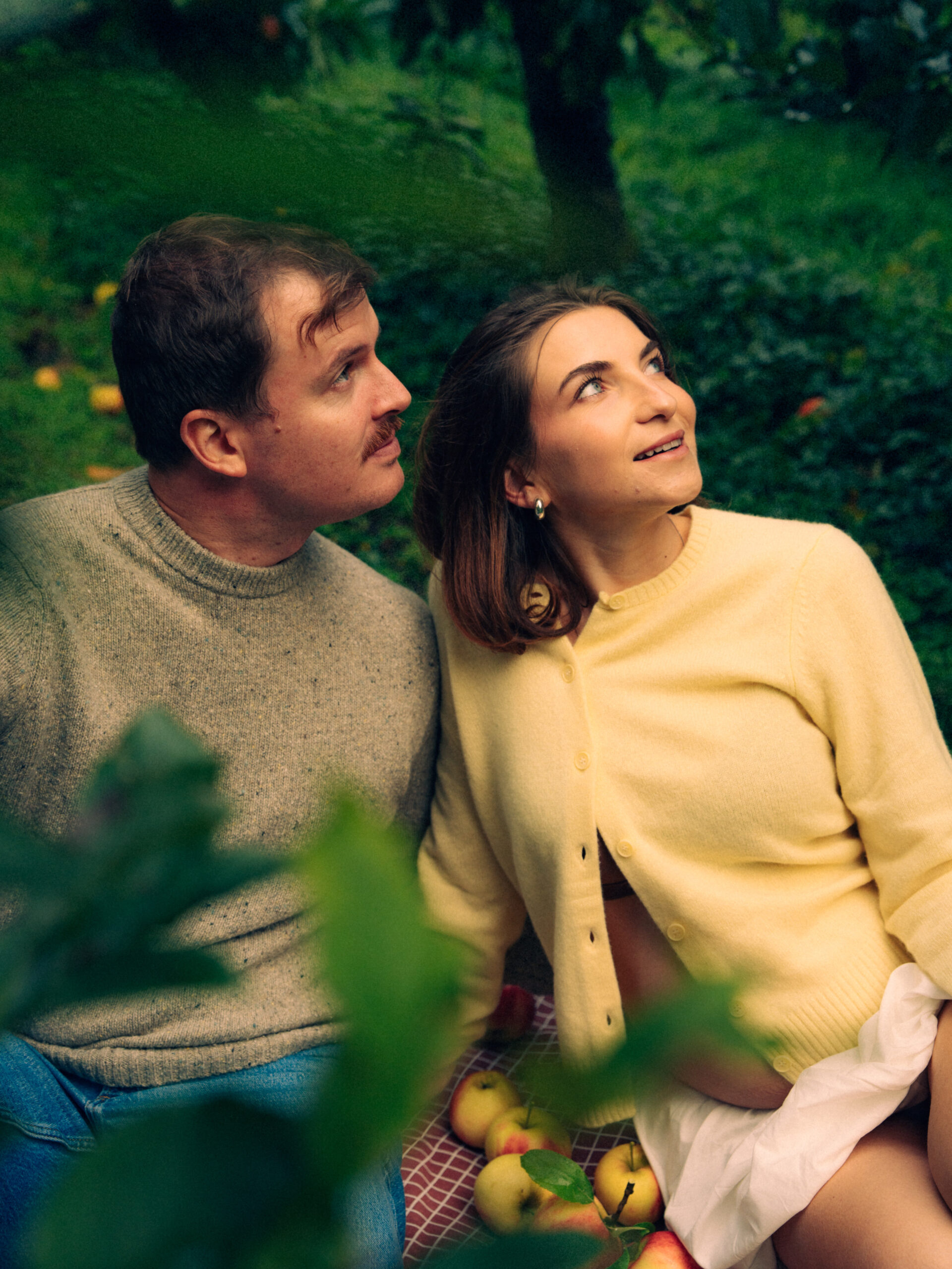 A cinematic photo of a couple at an apple orchard in the Netherlands.