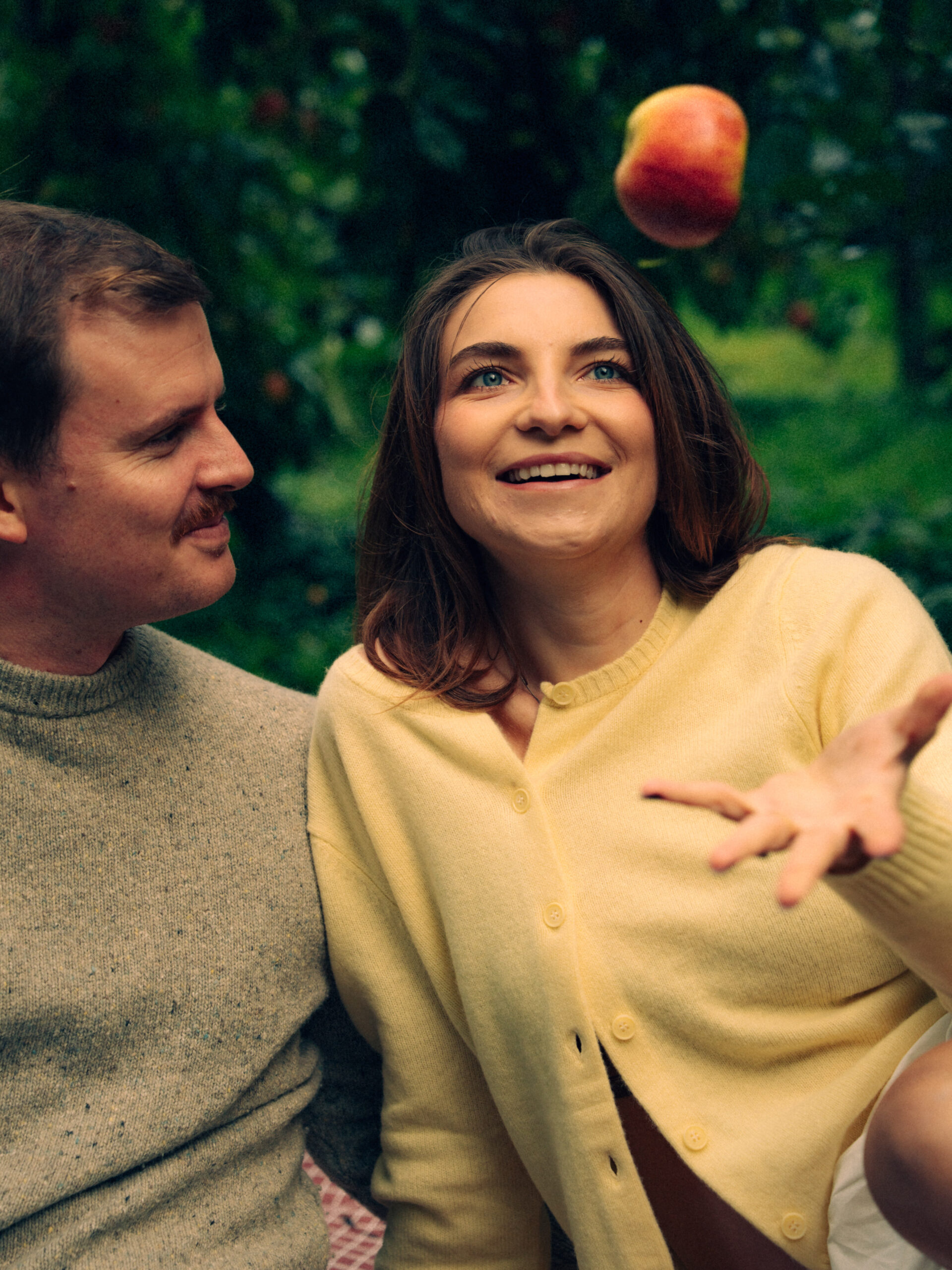 A cinematic photo of a couple at an apple orchard in the Netherlands.
