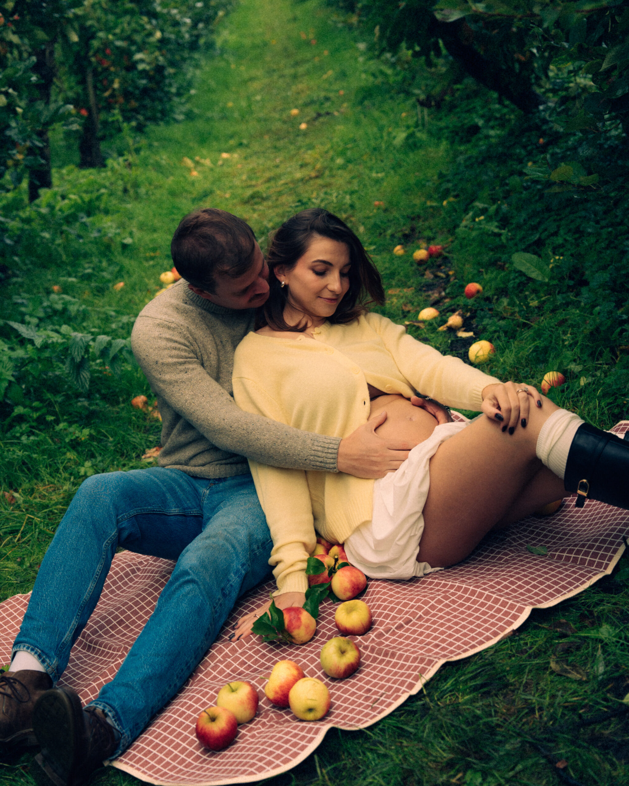A cinematic photo of a couple at an apple orchard in the Netherlands.