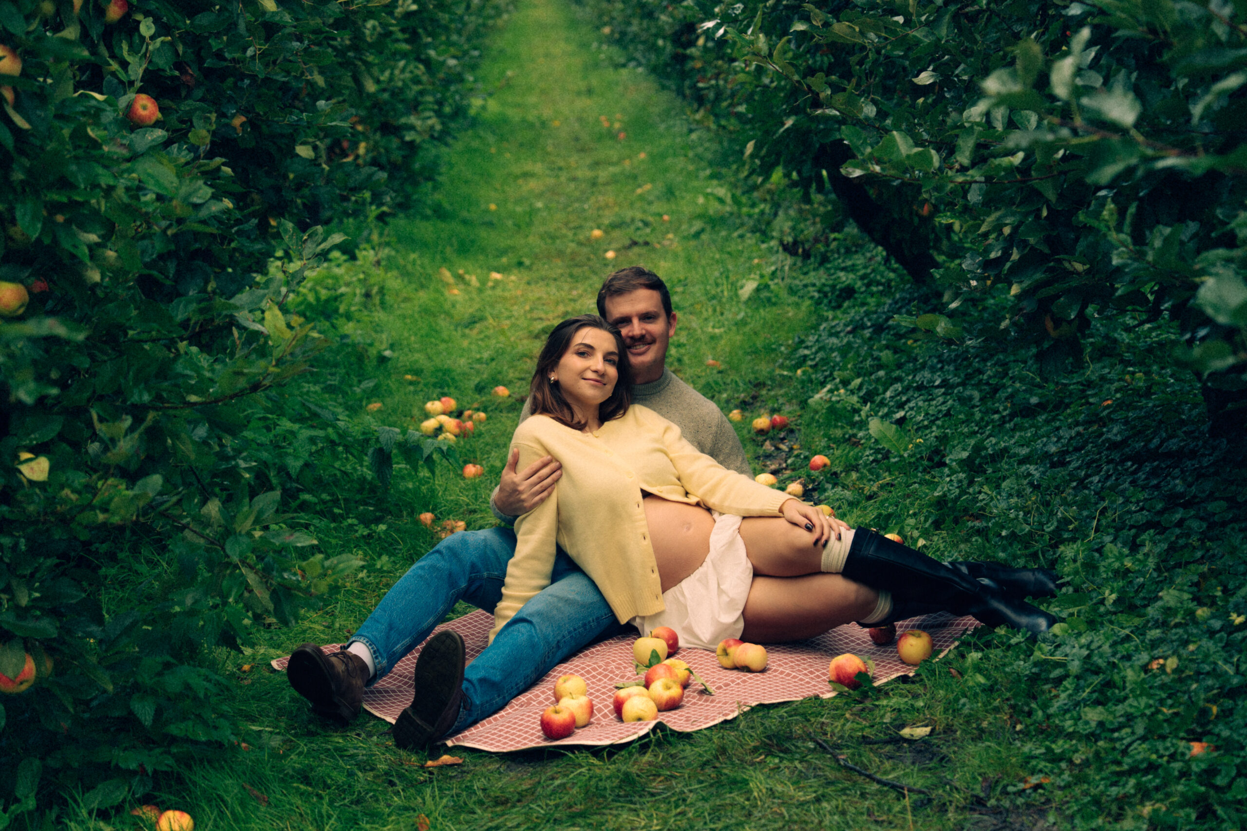 A cinematic photo of a couple at an apple orchard in the Netherlands.