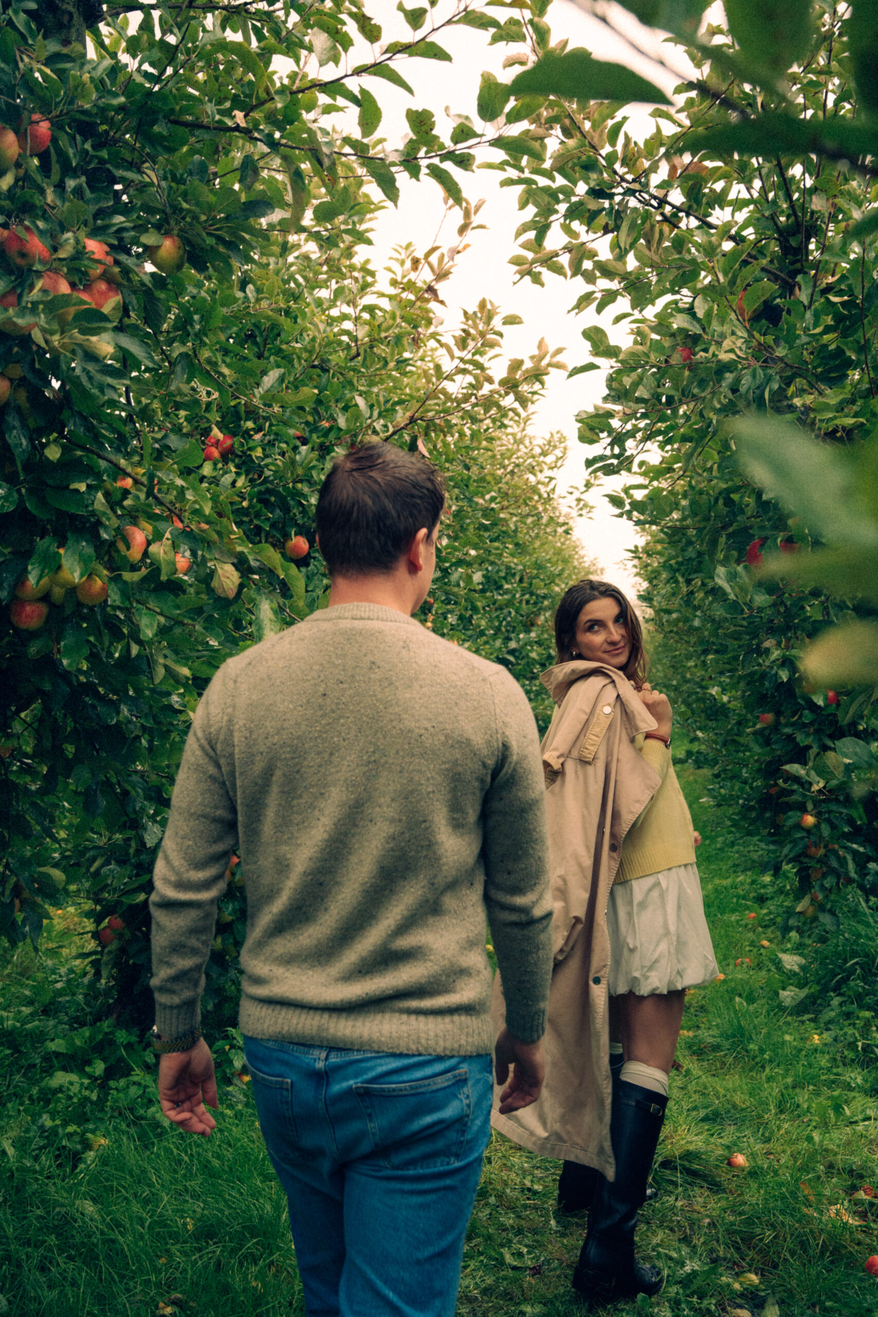 A cinematic photo of a couple at an apple orchard in the Netherlands.