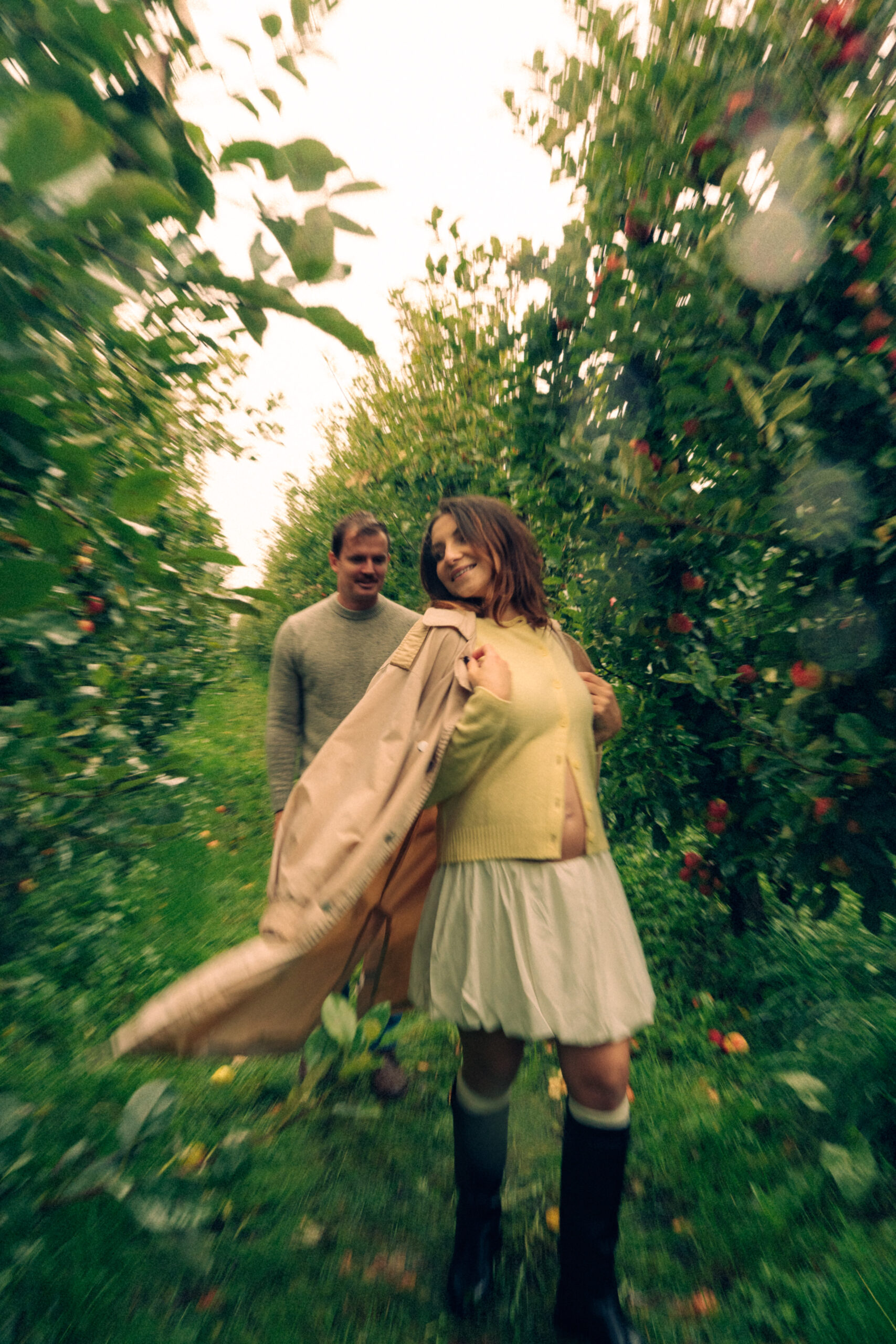 A cinematic photo of a couple at an apple orchard in the Netherlands.