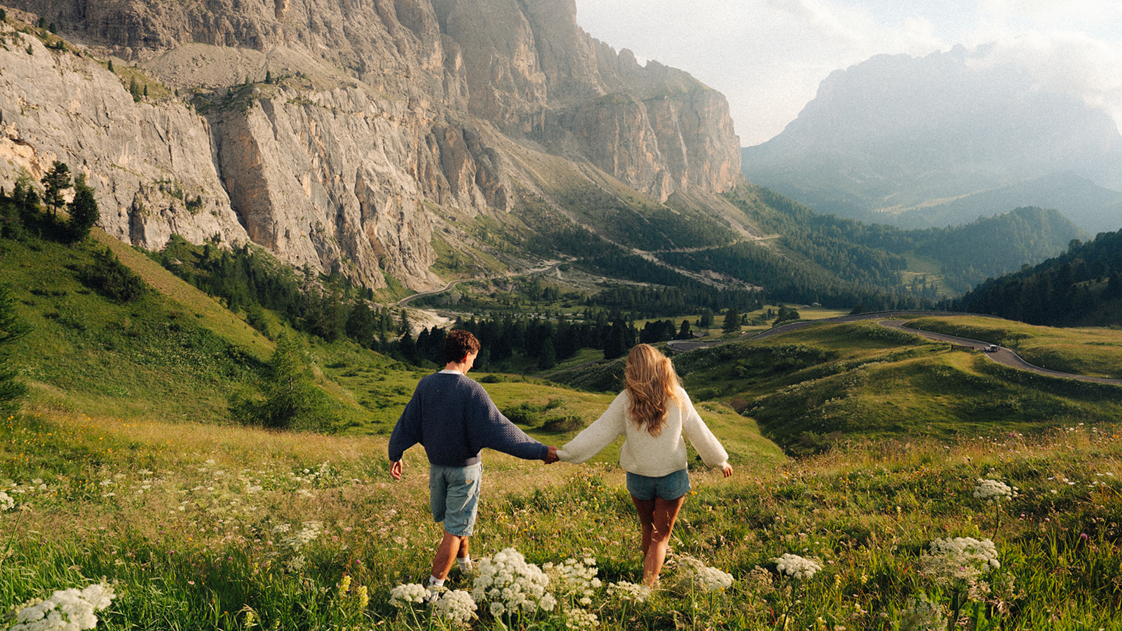 A cinematic photo of a couple posing with the Dolomites in the background.