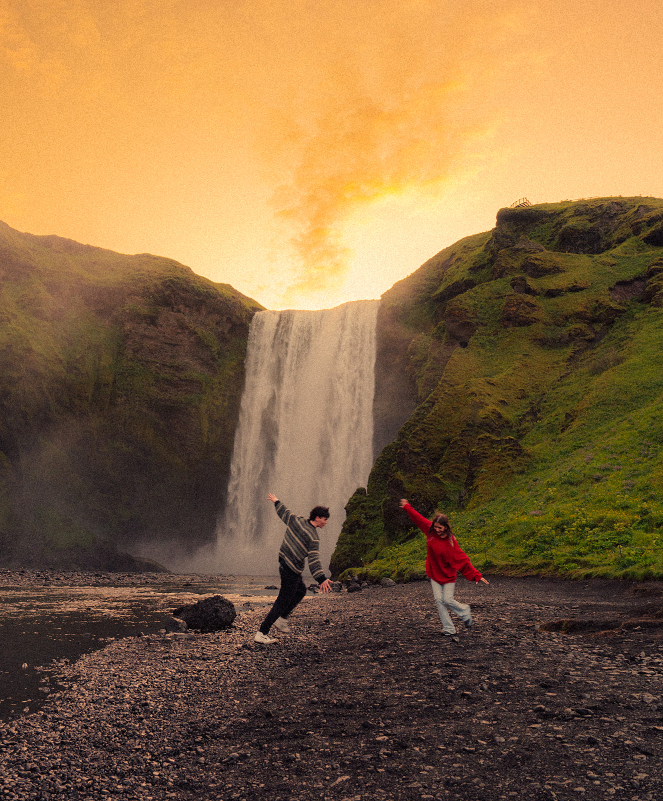 A cinematic epic photo of a couple in Skogafoss in Iceland.