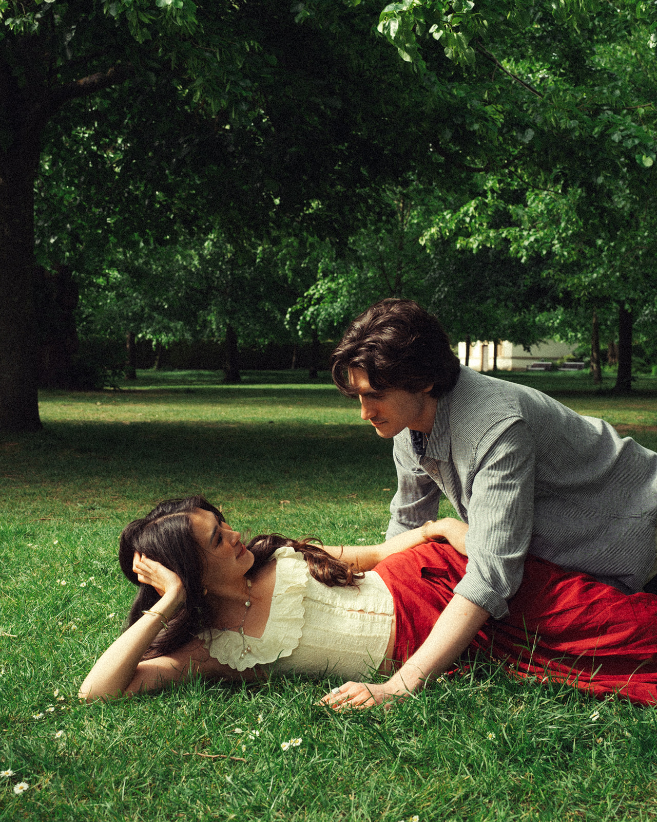 A cinematic photo of a couple in a park in England.